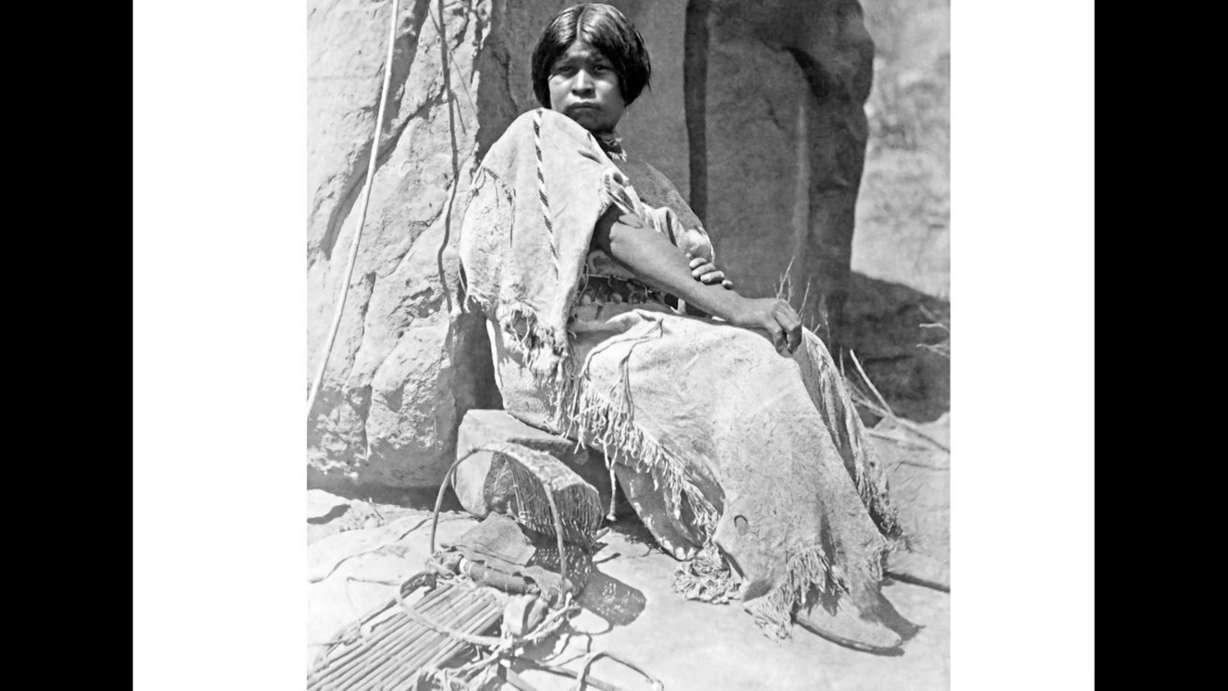 A photo of a Native American woman next to an empty cradle featured in the book, “The People: The Missing Piece of John Wesley Powell’s Expeditions,” which was released earlier this year. (Photo: Photo courtesy Thunderbird Foundation)