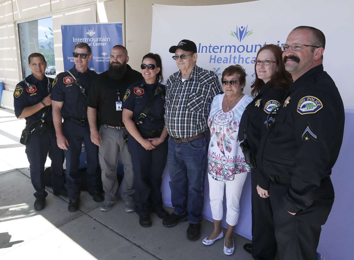 John Lindsey and his fiancee, Grett Williams, are photographed with first responders at Intermountain Medical Center in Murray on Monday, May 20, 2019. Lindsey thanked the firefighters and other motorists who helped save his life after he suffered a heart attack and crashed his truck on I-15 in South Salt Lake earlier this month. (Photo: Steve Griffin, KSL)