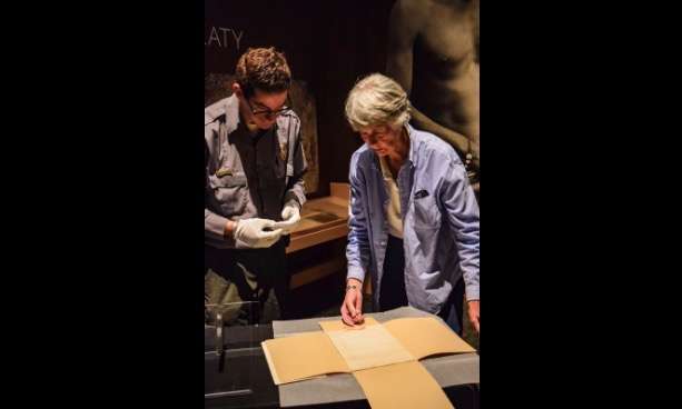 This June 6, 2018, photo provided by the New Mexico Historic Sites shows Clare "Kitty" Weaver, right, and Fort Sumner Historic Site Manager, Aaron Roth preparing the Navajo Treaty of 1868 for display for the 150th Commemoration of its signature at Bosque Redondo Memorial at Fort Sumner, N.M. (New Mexico Historic Sites via AP)