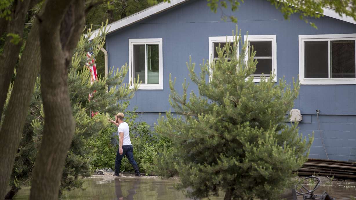 The Latest: Residents seek shelter after river floods homes