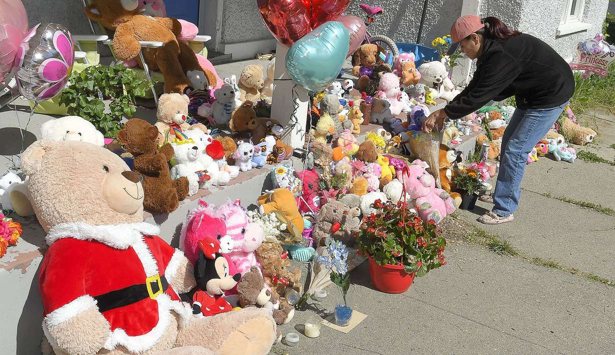 Betty Balls puts flowers on the porch at Elizabeth Shelley's home on Thursday, May 30, 2019, in Logan. Hundreds of items were left at the house where the 5-year-old went missing, less than a block from where her body was found on Wednesday, May 29. (Photo: Eli Lucero, The Herald Journal)