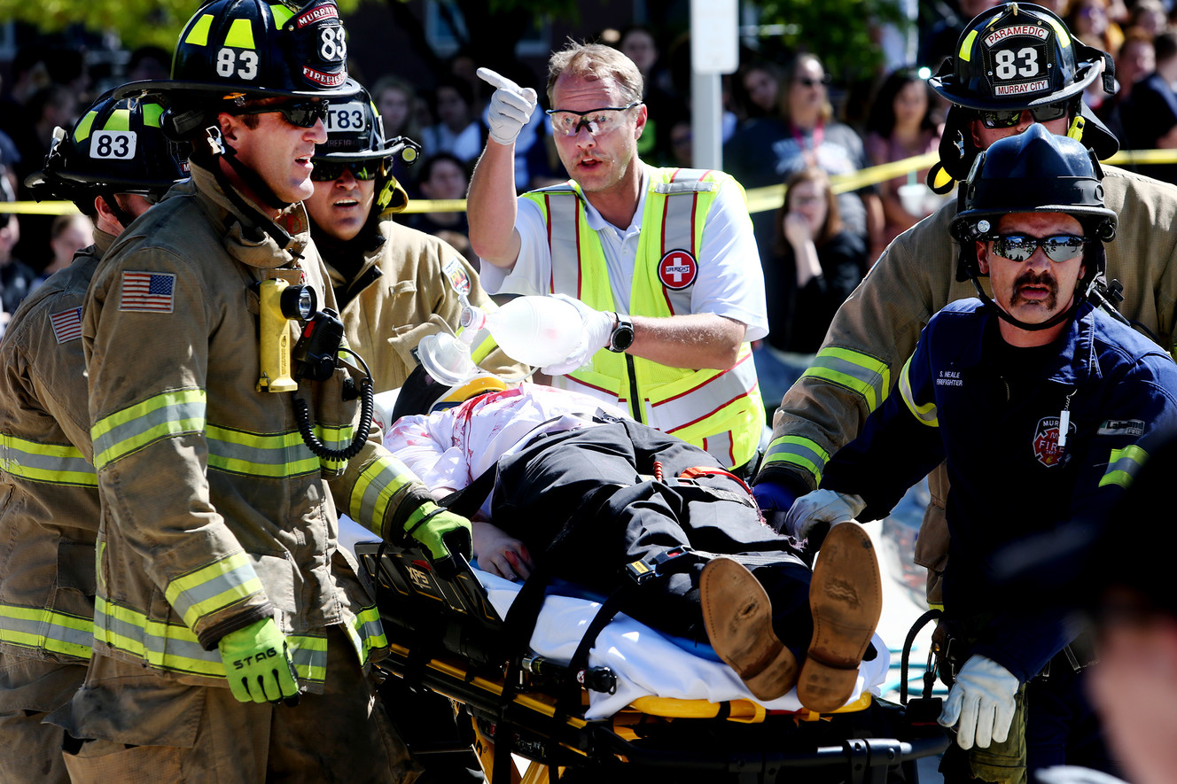 Emergency crews rush a “patient” to an Intermountain Life Flight helicopter during a mock car crash demonstration at Murray High School on Friday, May 31, 2019. (Photo: Scott G Winterton, KSL)