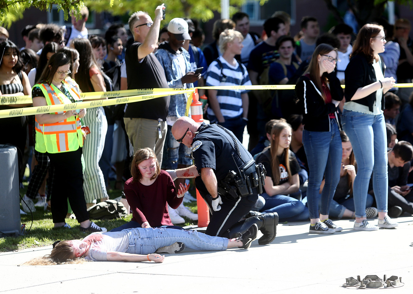 Murray police officer Brad Astin checks on “patients” during a mock car crash at Murray High School on Friday, May 31, 2019. (Photo: Scott G Winterton, KSL)