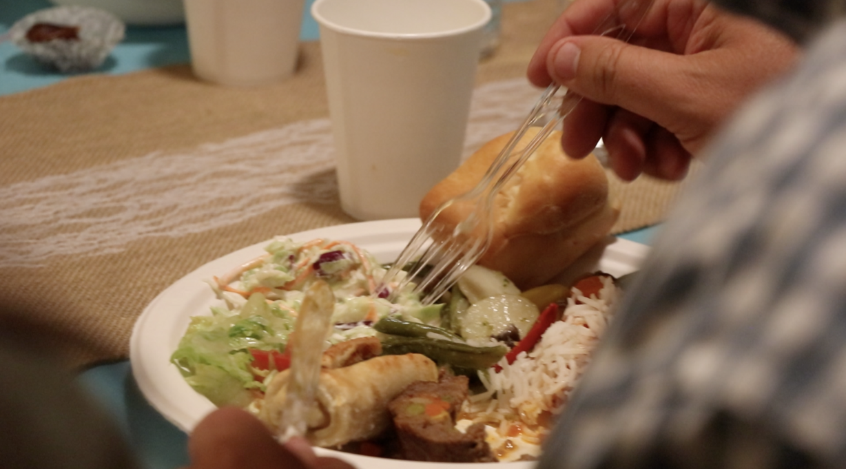 The Kariparduc's neighbors load their plates with traditional Turkish food during iftar Saturday, June 1, 2019. (Photo: Liesl Nielsen, KSL.com)