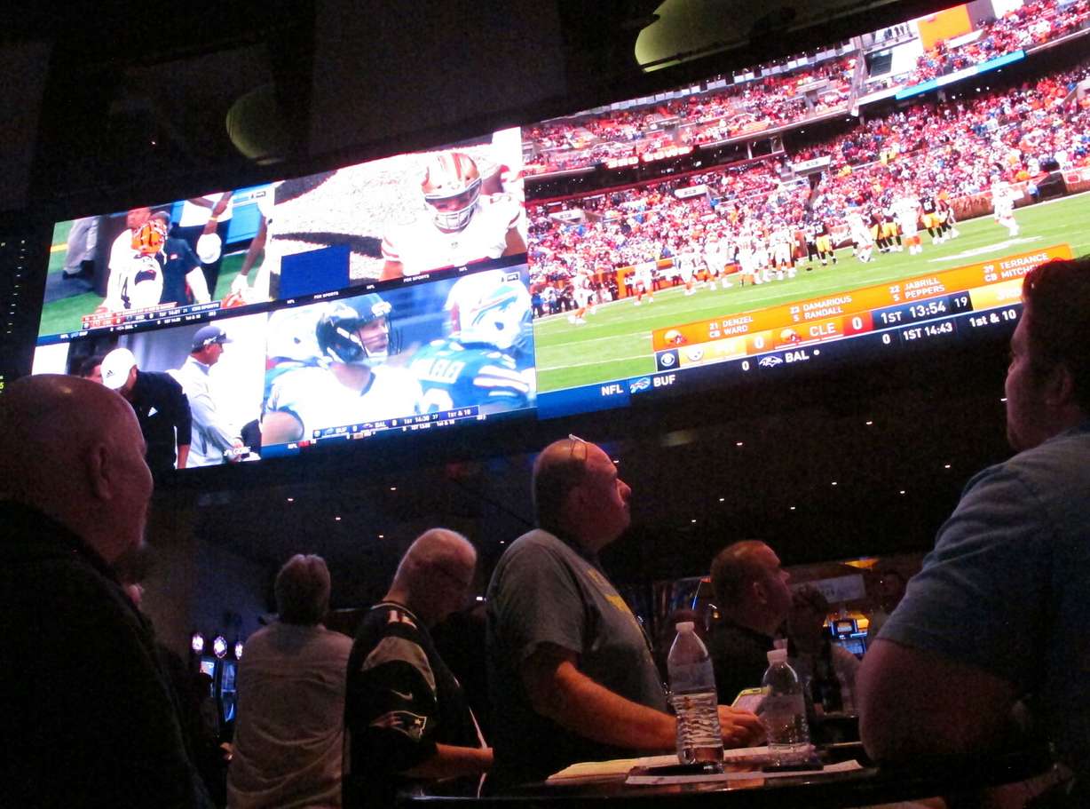 In this sept. 9, 2018 photo, customers watch sports on a giant screen at the sports book of the Ocean Resort Casino in Atlantic City, N.J. Panelists at a gambling conference in Atlantic City on Thursday, June 13, 2019, predicted 90% of all US sports betting will be done online or over smart phones within the next 10 years.