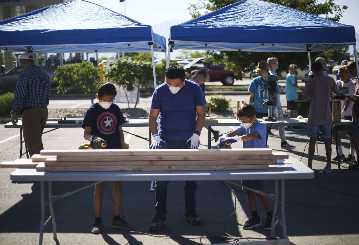Lehi residents Ben Perez and his sons Benny, 12, and Kyle, 9, work on making bunk beds as volunteers with the Sleep in Heavenly Peace nonprofit during an event called Bunks Across America in Lehi on Saturday, June 15, 2019. The group expected to have close to 150 volunteers throughout the day working to make 25 bunk beds for children in Utah. (Photo: Silas Walker, KSL)