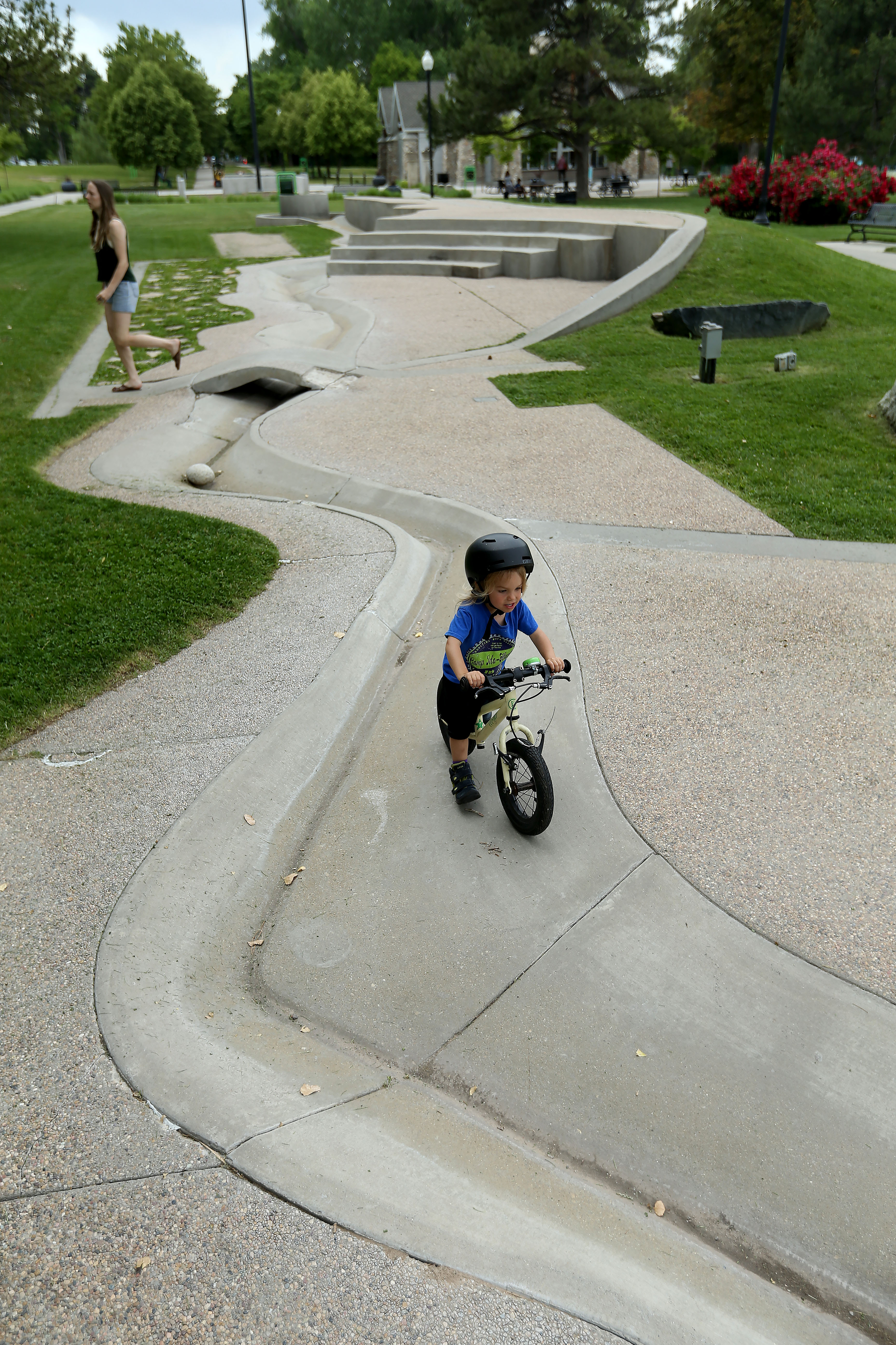 Finn Carper, 3, rides his bike through the Seven Canyons Fountain in Liberty Park in Salt Lake City on Thursday, June 13, 2019. The fountain was closed two years ago due to health and safety concerns. The city is now working to come up with solutions and funding to reopen it. (Laura Seitz, KSL)