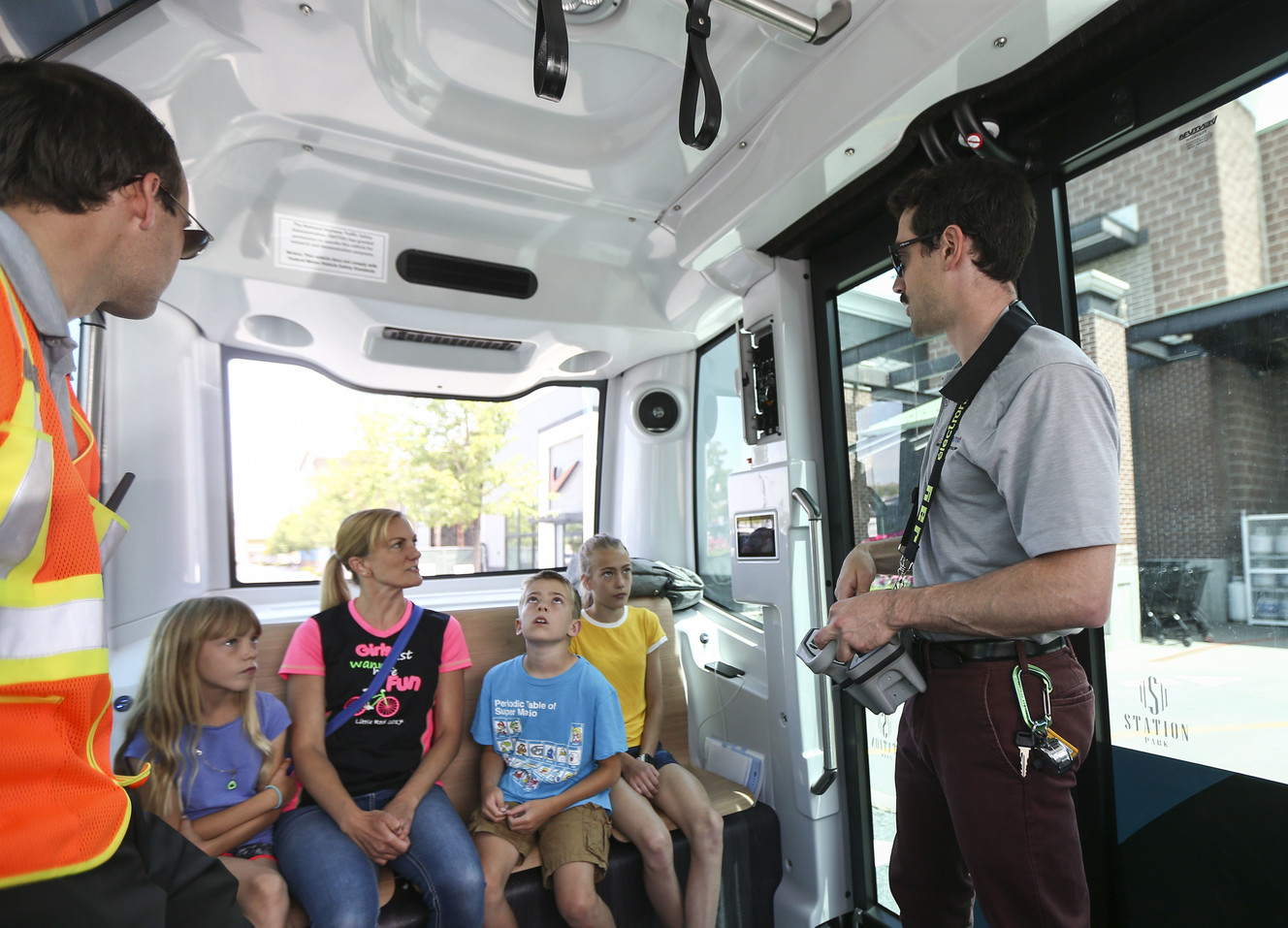 Colin Timm, deployment engineer with EasyMile, explains to Julie Willoughby and her children how the driverless shuttle works as they take a ride at Station Park in Farmington on Monday, June 17, 2019. (Photo: Silas Walker, KSL)
