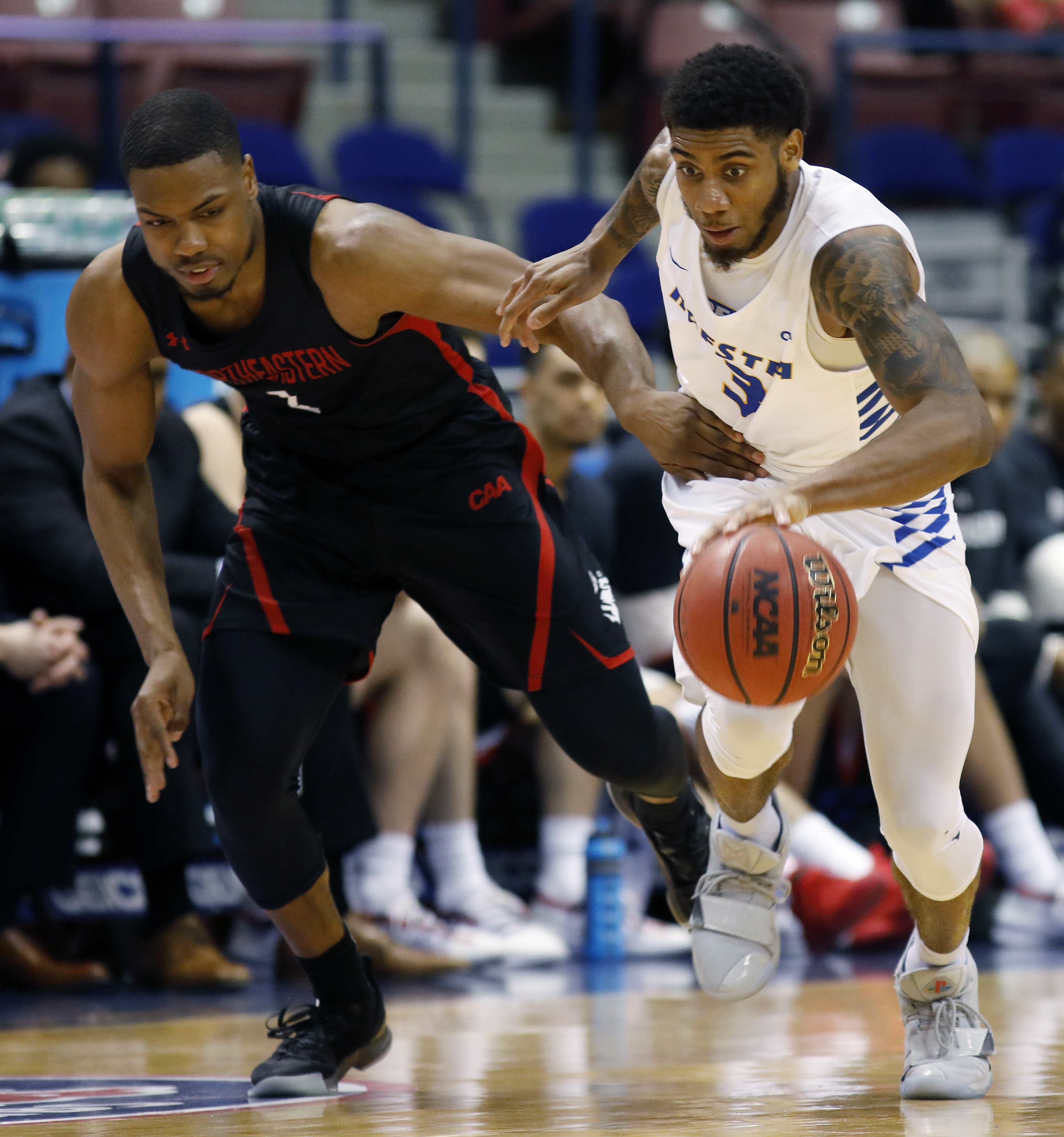 Hofstra's Justin Wright-Foreman, right, and Northeastern's Shawn Occeus fight for control of the ball during an NCAA college basketball game at the Colonial Athletic Association men's basketball championship, Tuesday, March 12, 2019, in North Charleston, S.C. Northeastern defeated Hofstra 82-74. (Photo: Mic Smith, AP)