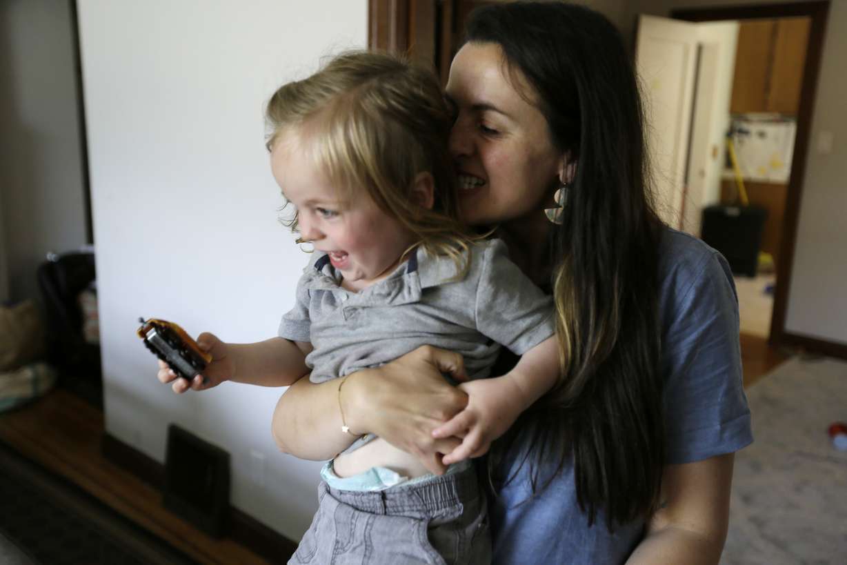 In this Thursday, June 6, 2019 photo, Sarah Montoya picks up her twin son, Nicasio, at their home in San Francisco. Photo: Eric Risberg