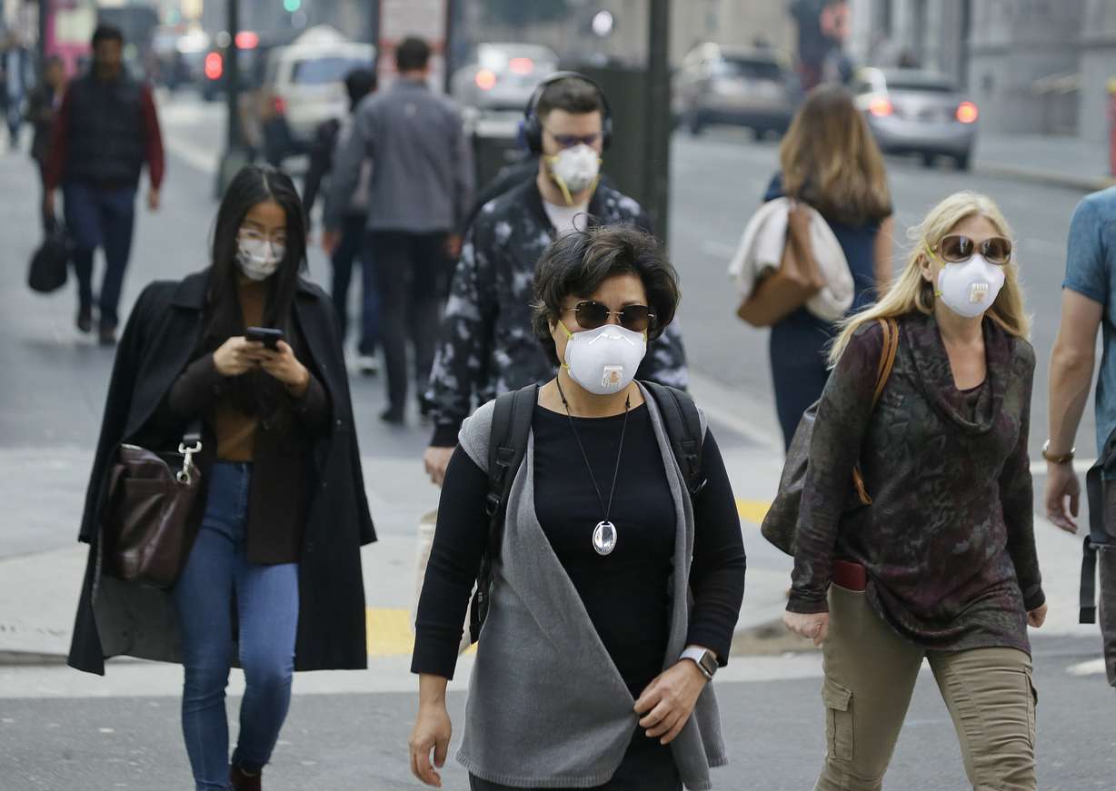 FILE - In this Nov. 9, 2018, file photo, people wear masks while walking through the Financial District in the smoke-filled air in San Francisco. Photo: Eric Risberg, AP Photo