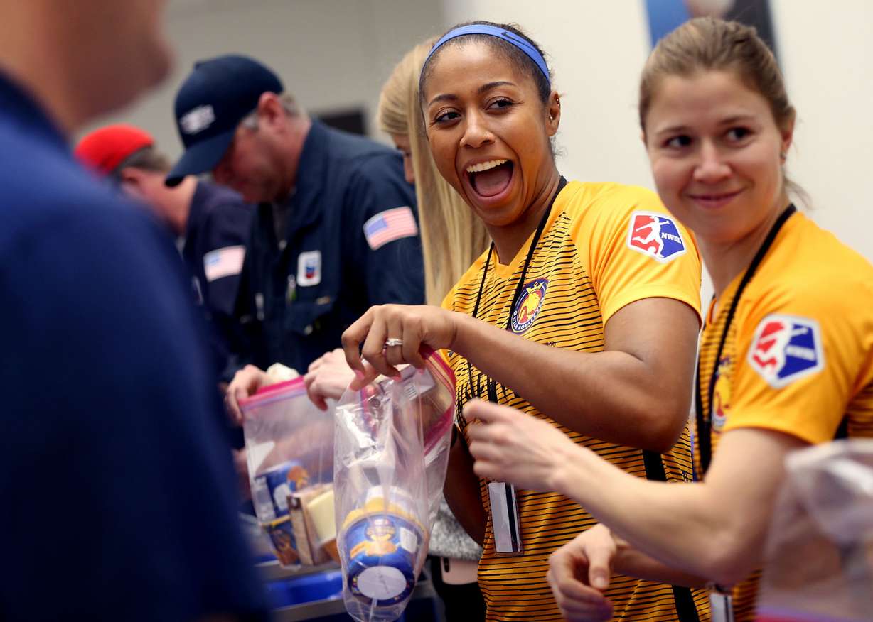 Utah Royals' Abby Smith, center, and Becca Moros, right, help assemble 5,000 “pantry packs” to feed children with food insecurity in Davis County at the Chevron Salt Lake Refinery Administration Building in North Salt Lake on Thursday, Feb. 28, 2019. (Photo: Laura Seitz, KSL)