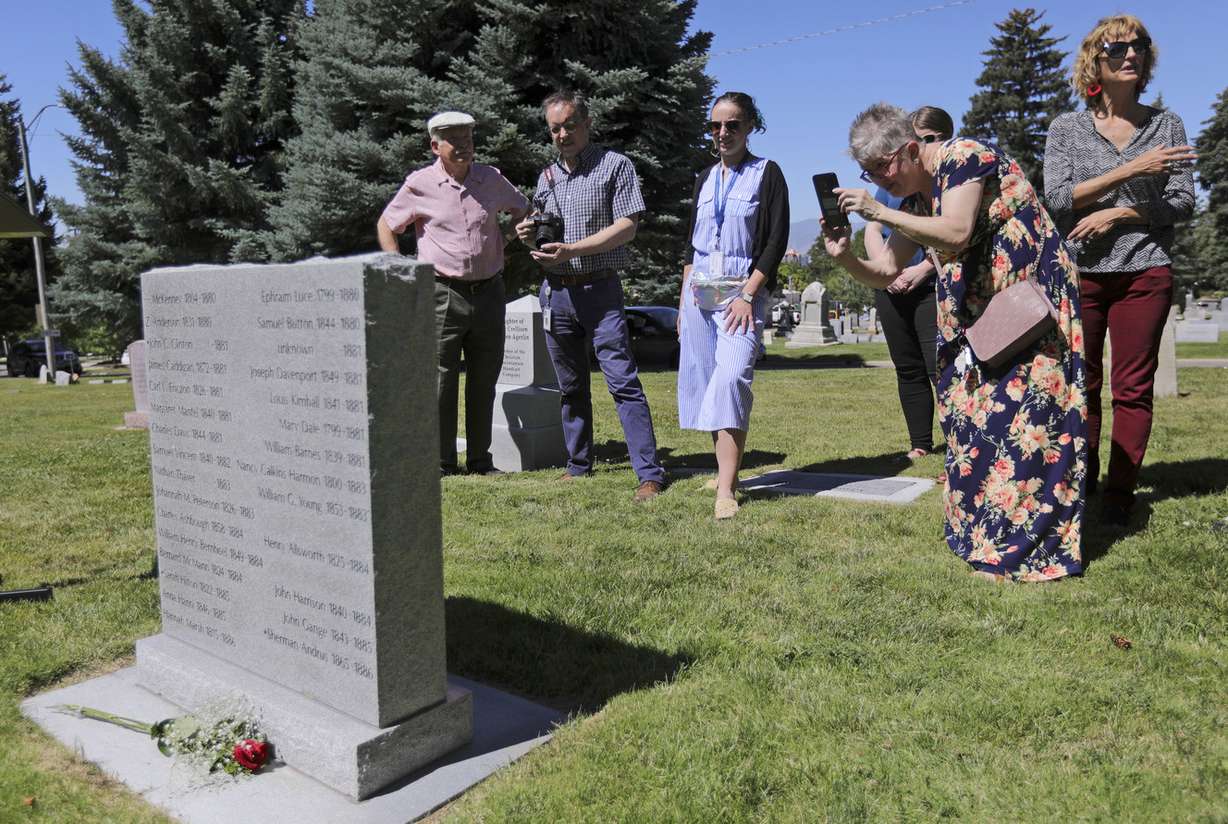 Wendy Fayles, mentor with the Utah chapter of the National Alliance on Mental Illness, takes a photo of a new granite marker memorializing those who died in the state’s first insane asylum following a dedication ceremony at the Salt Lake City Cemetery on Tuesday, July 2, 2019. (Photo: Kristin Murphy, KSL)