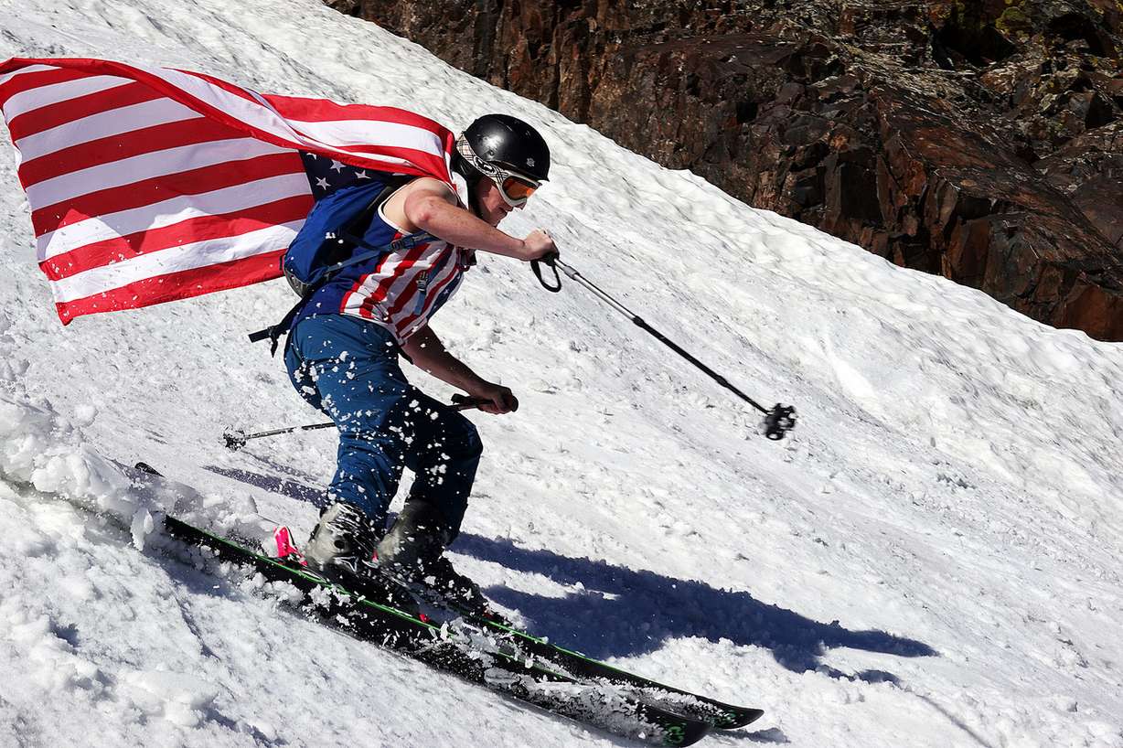 Daniel Wells skis with a flag over his shoulders at Snowbird on Thursday, July 4, 2019. (Photo: Ravell Call, KSL)