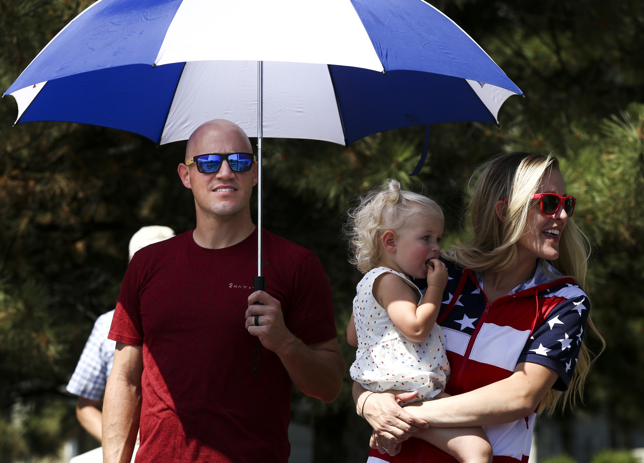 Ben Clark, left, Jen Clark, right, and their daughter Jori Clark, 1, watch the West Jordan Stampede Grand Parade on Thursday, July 4, 2019, in West Jordan. (Photo: Colter Peterson, KSL)
