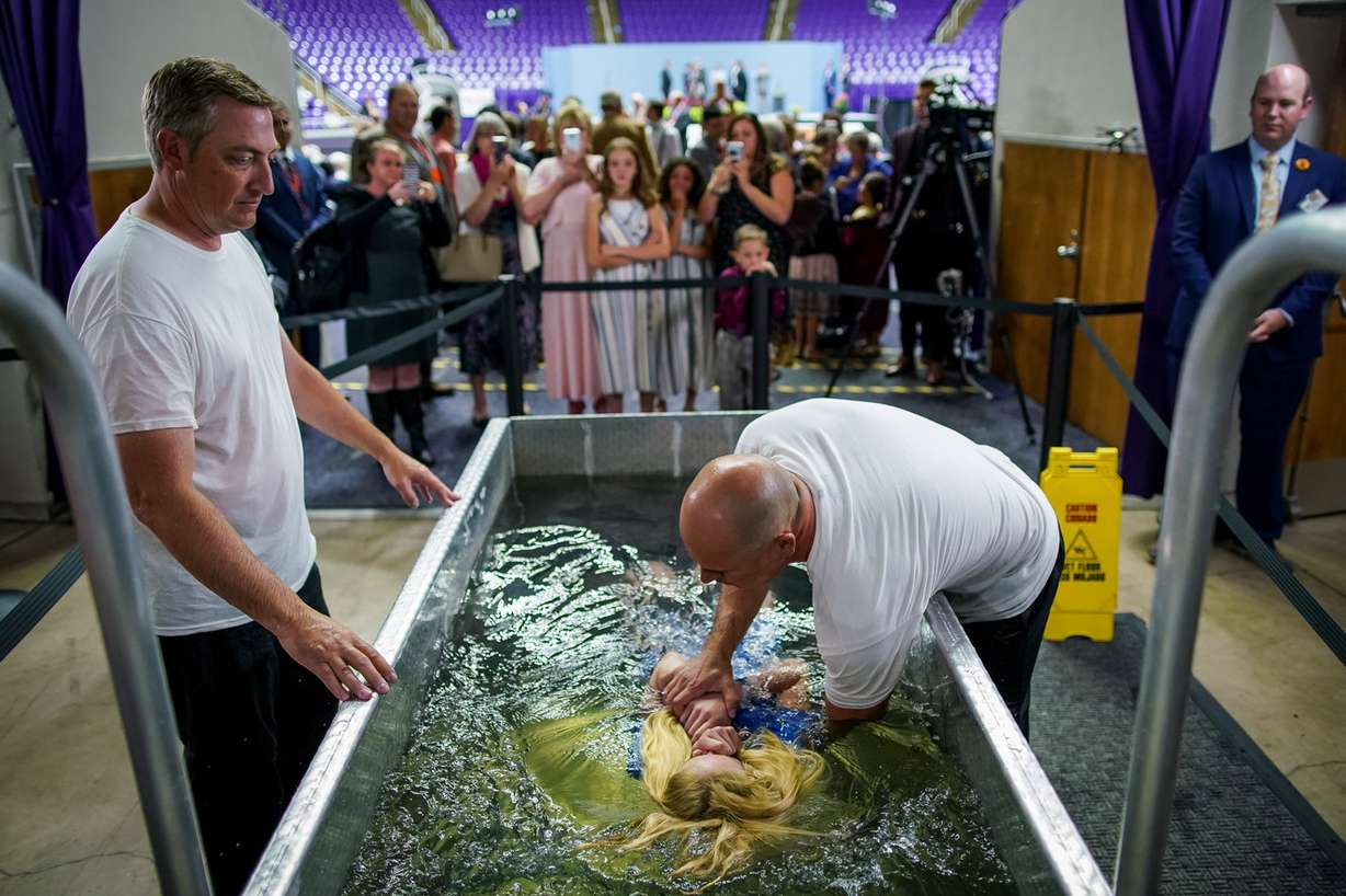 Jesse Taylor, left, and Corey Van Buren, right, assist Sobe Barber, 11, of Rock Springs, Wyo., during her baptism at the Jehovah's Witnesses convention at the Dee Events Center in Ogden on Saturday, July 6, 2019. (Photo: Spenser Heaps, KSL)
