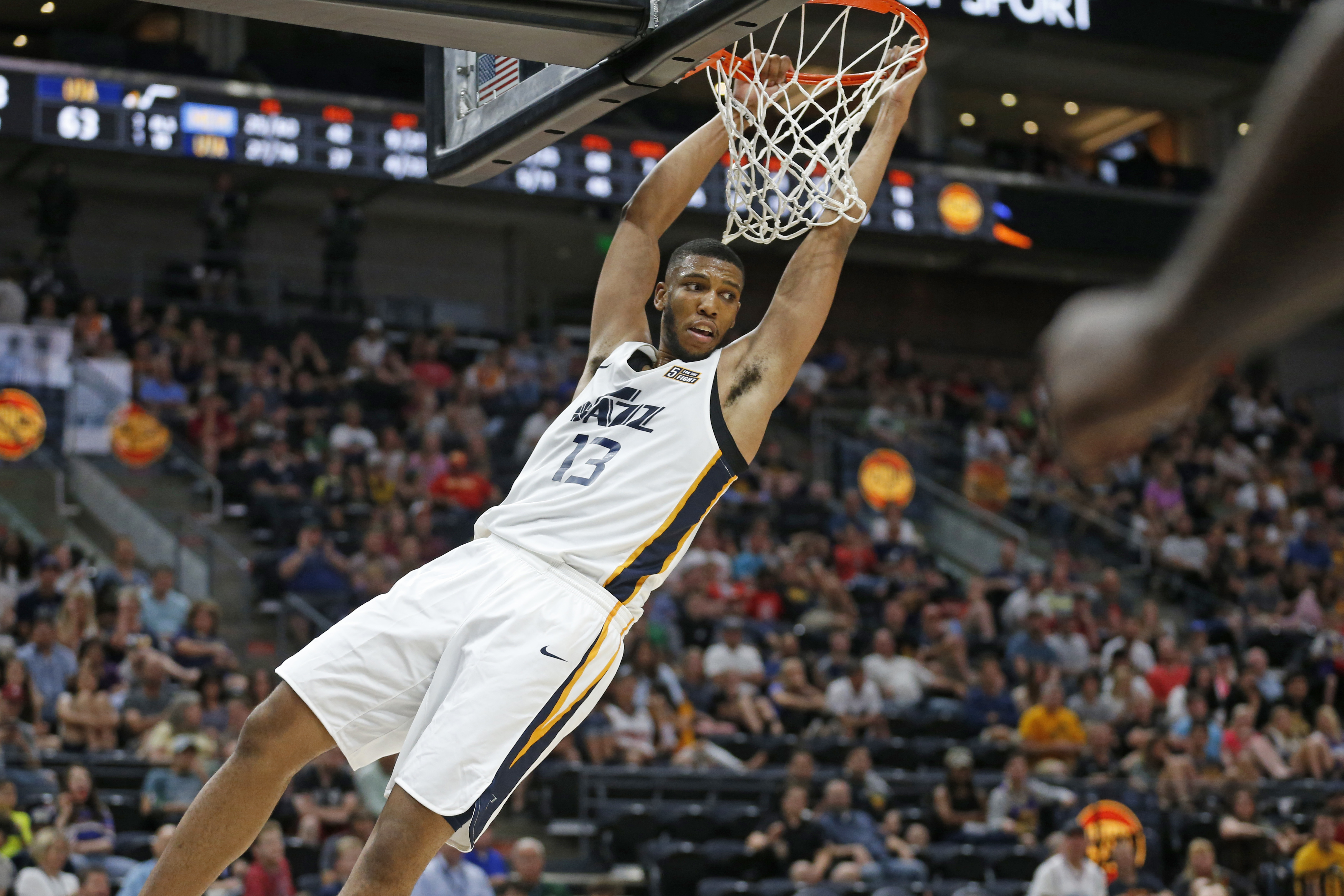 Utah Jazz Tony Bradley (13) hangs after dunking against the Memphis Grizzlies during the second half of an NBA summer league game Monday, July 1, 2019, in Salt Lake City. (AP Photo/Rick Bowmer)