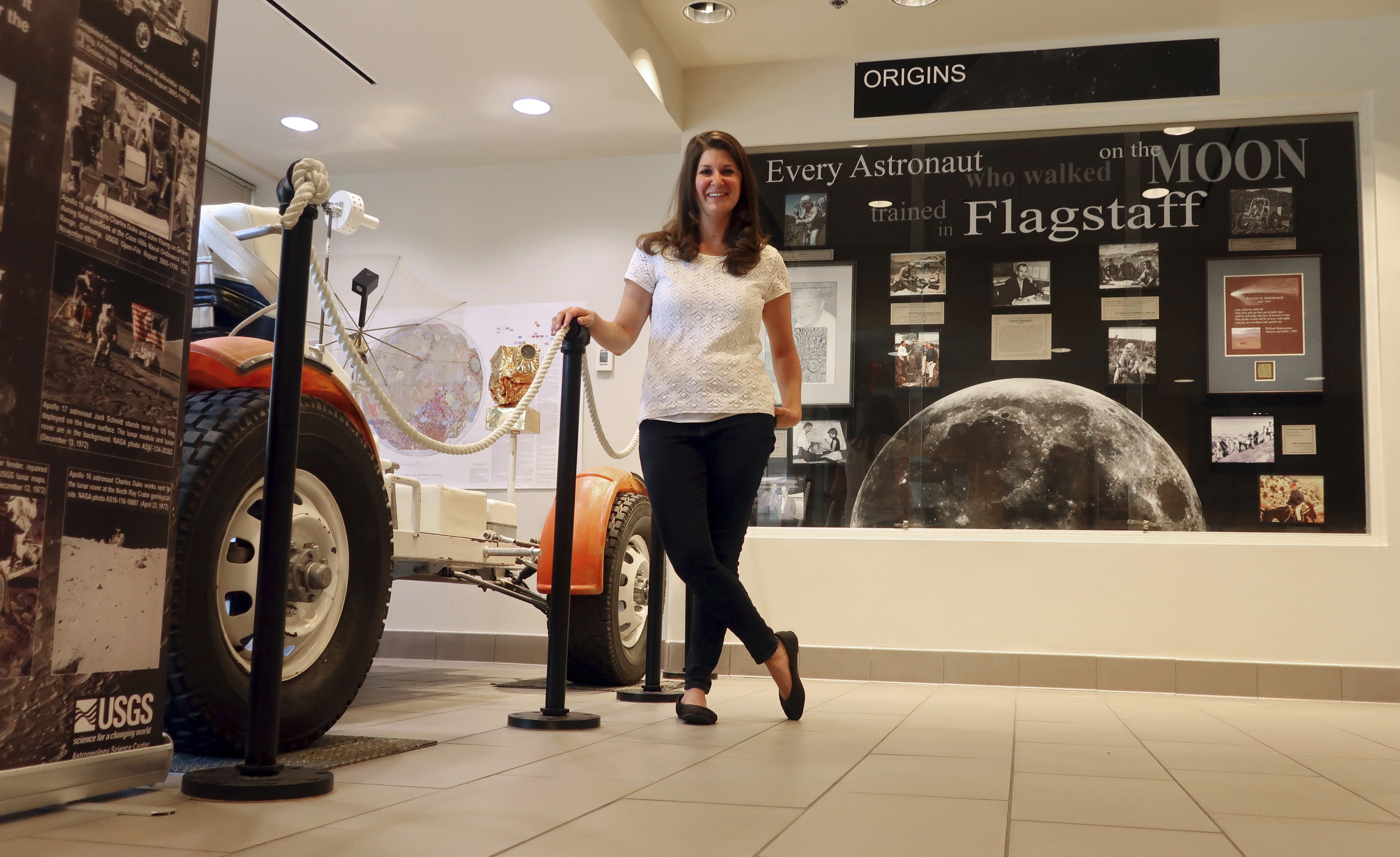 In this June 25, 2019 photo, Lauren Edgar, a research geologist for the U.S. Geological Survey's Astrogeology Science Center in Flagstaff, Ariz., poses in front of a prototype of a lunar rover. (AP Photo/Felicia Fonseca)