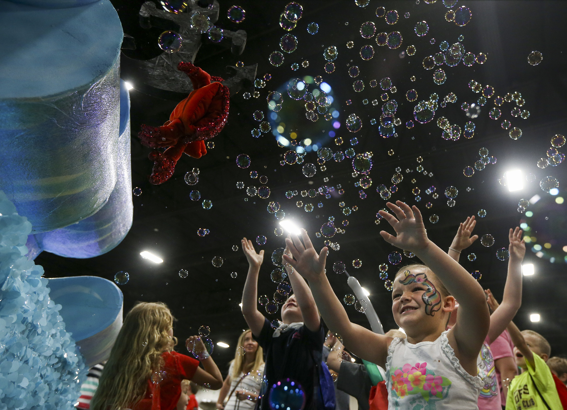 Ruby Tappana, 5, jumps after bubbles coming from the West Jordan, UT. Stake float during the Days of 47 Float Preview at the Mountain America Expo Center in Sandy on Monday, July 22, 2019. Float makers put their floats on display Monday and Tuesday for the community to get up close before the parade. (Photo: Colter Peterson, KSL.)