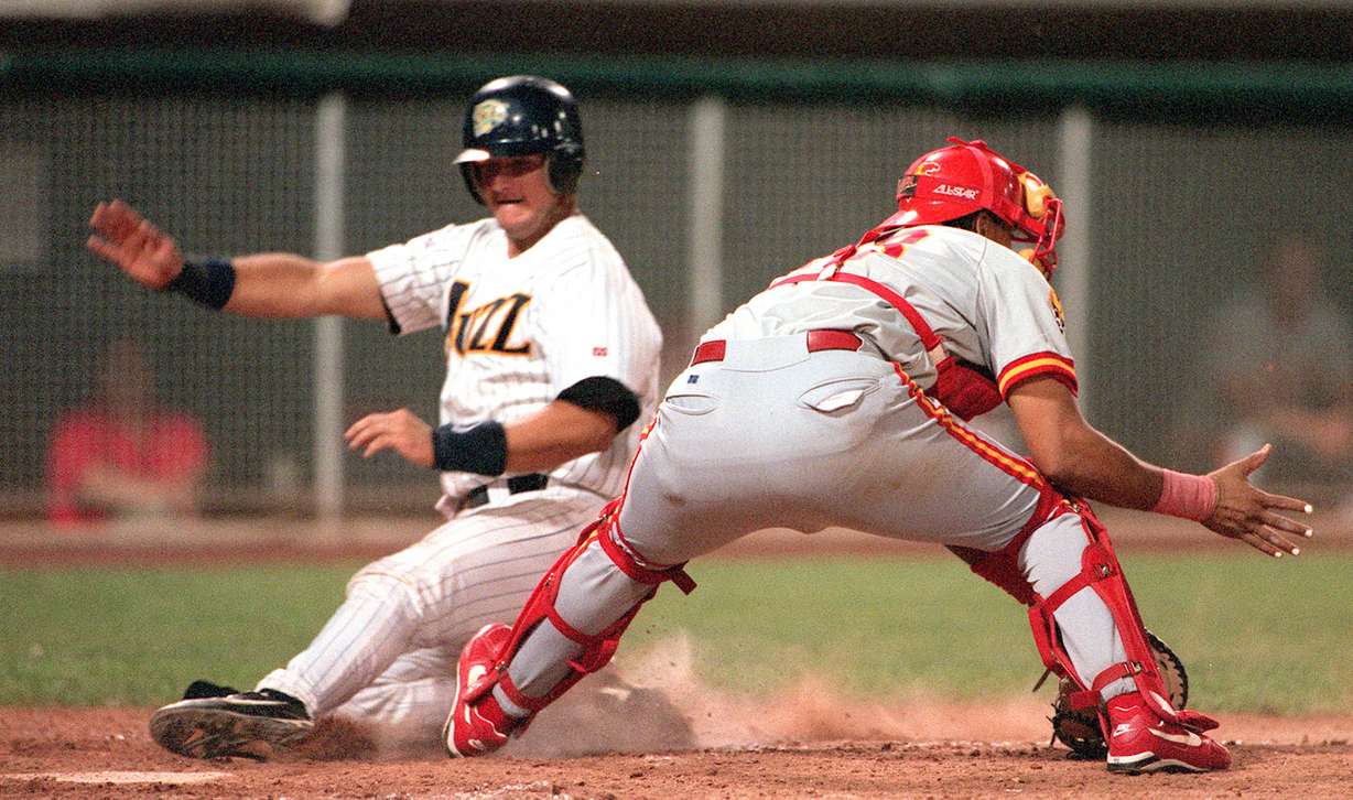 Salt Lake Buzz catcher A.J. Pierzynski slides into home to score the winning run as Albuquerque catcher Henry Blanco fields the ball too late to make a tag on July 21, 1998. (Photo: Gary McKellar, Deseret News Photo Archives)