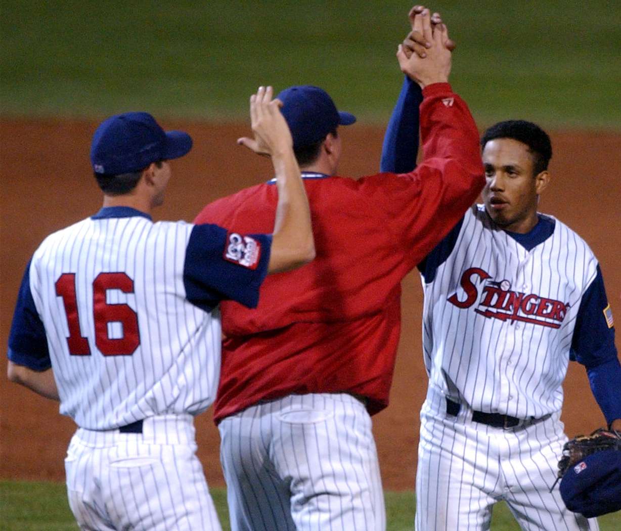 Stinger's pitcher Francisco Rodriguez gets high fives from teammates after finishing off the first playoff game against Oklahoma with a win, Wednesday, September 4, 2002. (Photo: Johanna Workman, Deseret News Photo Archives)