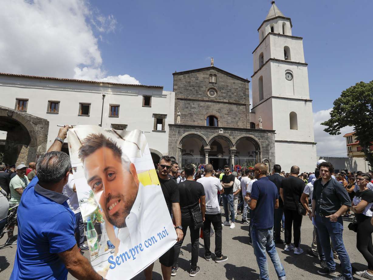 People unfold a banner reading in Italian: "Forever with us", and bearing a photograph of Carabinieri's officer Mario Cerciello Rega during his funeral in his hometown of Somma Vesuviana, near Naples, southern Italy, Monday, July 29, 2019. Photo: Andrew Medicini, AP Photo