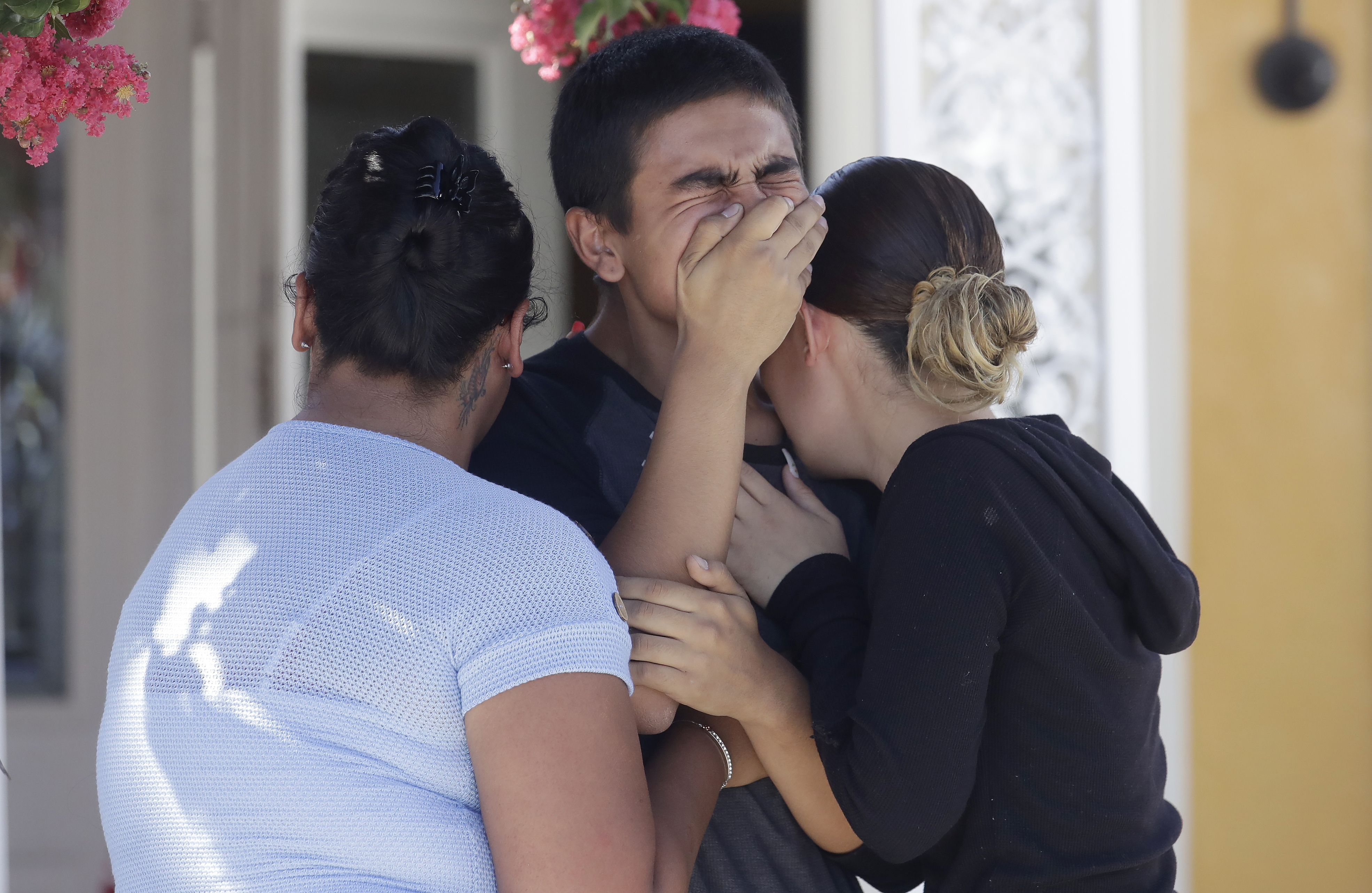 Joshua Guicho, 16, center, cries between his aunts Josephine Guicho, left, and Erica Guicho while being interviewed about the shooting death of his 6-year-old cousin Stephen Romero in San Jose, Calif., Monday, July 29, 2019. Romero is one of three young people who died when a gunman opened fire at a popular California food festival Sunday. (Jeff Chiu, AP Photo)