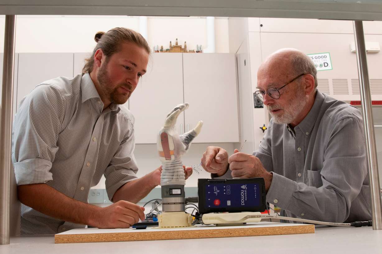 Greg Clark (right) and Jake George (left) with the LUKE arm. (Photo: Dan Hixson, University of Utah College of Engineering)