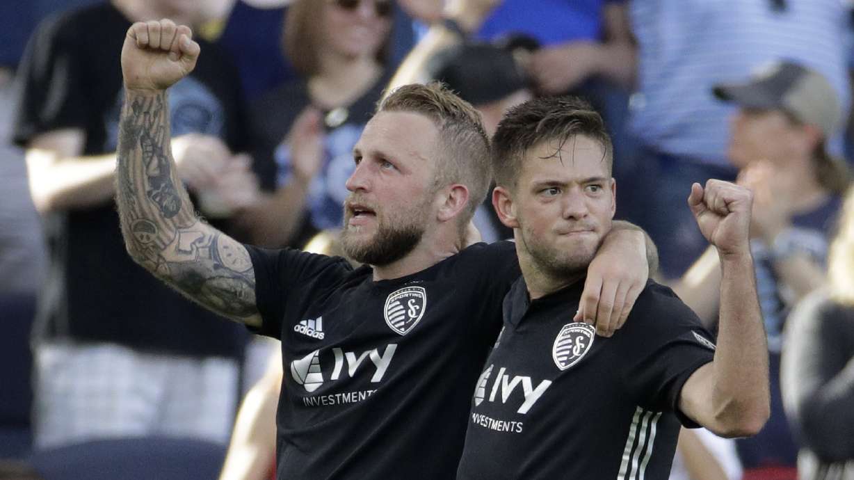 Sporting Kansas City forward Johnny Russell, left, and midfielder Kelyn Rowe, celebrate after Russell scored a goal during the second half of an MLS soccer match Sunday, May 26, 2019, in Kansas City, Kan. Sporting won 3-2. (AP Photo/Charlie Riedel)
