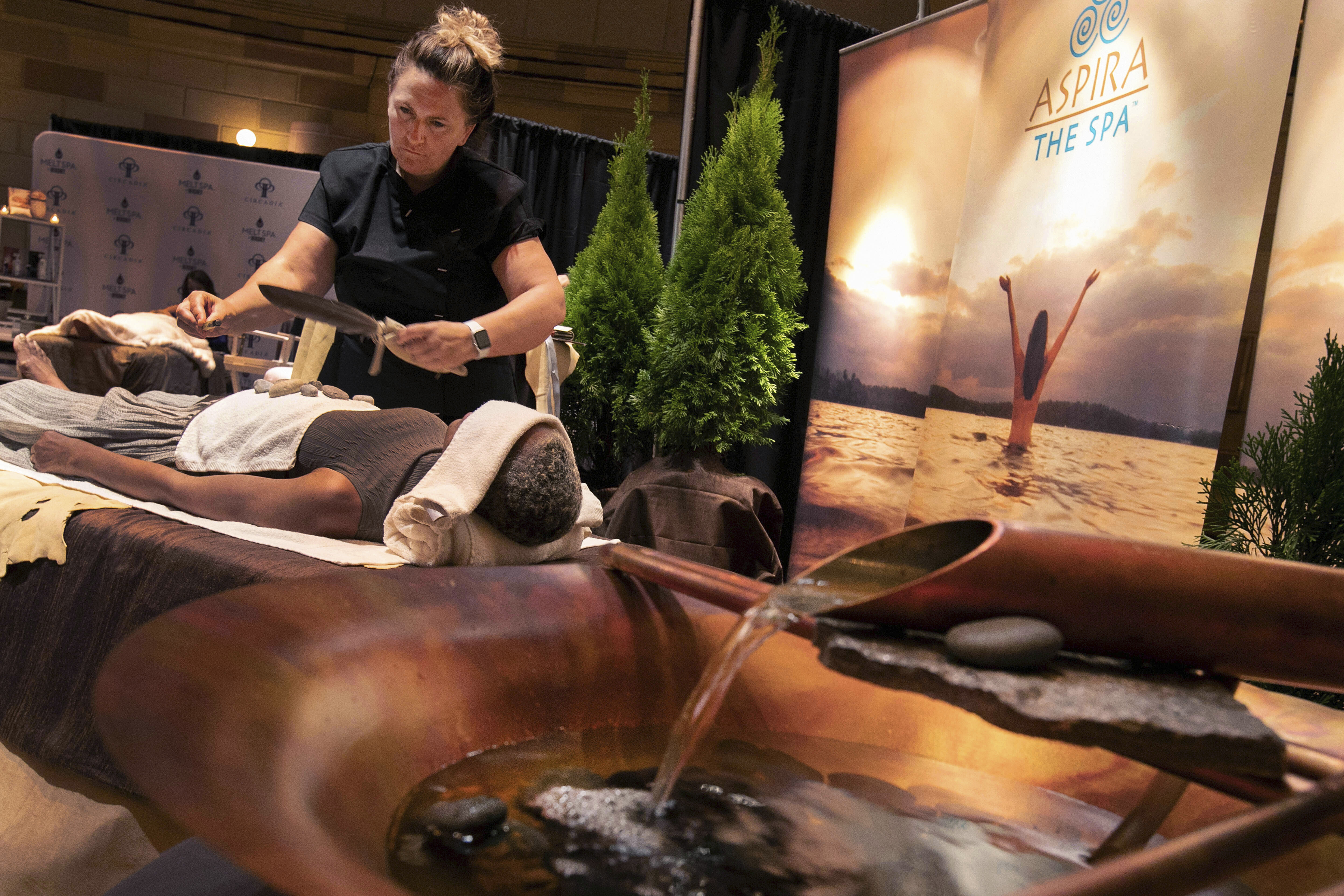 In this Tuesday, Aug. 6, 2019, photo, lead therapist Mickaela Sommers, at Aspira Spa at the Ostoff Resort, in Elkhart Lake, Wisc., demonstrates DOHI, a tribal purifying and cleansing ritual, during the 2019 International Spa Association event. Photo: Richard Drew, AP Photo