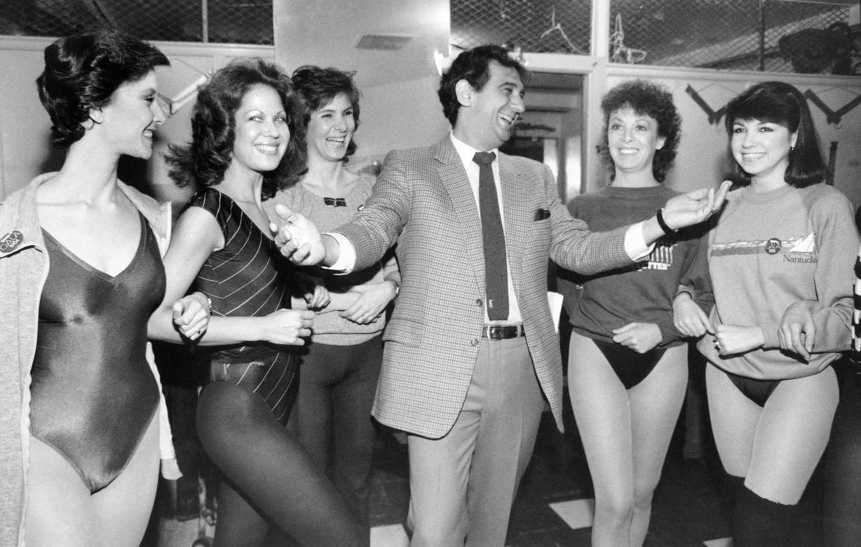FILE - In this Feb. 27, 1984, file photo, singer Placido Domingo laughs with members of the Rockettes at New York's Radio City Music Hall. (Steve Friedman, AP Photo, File)