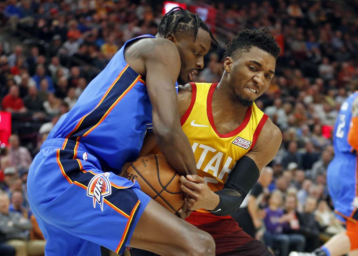Oklahoma City Thunder forward Jerami Grant, left, and Utah Jazz guard Donovan Mitchell, right, battle for the ball in the first half during an NBA basketball game, Monday, March 11, 2019, in Salt Lake City. (Rick Bowmer, AP Photo)