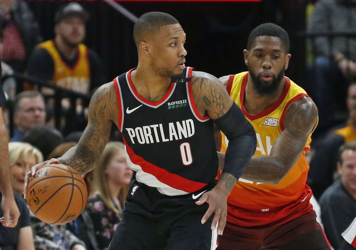 Utah Jazz forward Royce O'Neale, right, guards Portland Trail Blazers guard Damian Lillard (0) during the first half in an NBA basketball game Monday, Jan. 21, 2019, in Salt lake City. (Rick Bowmer, AP Photo)