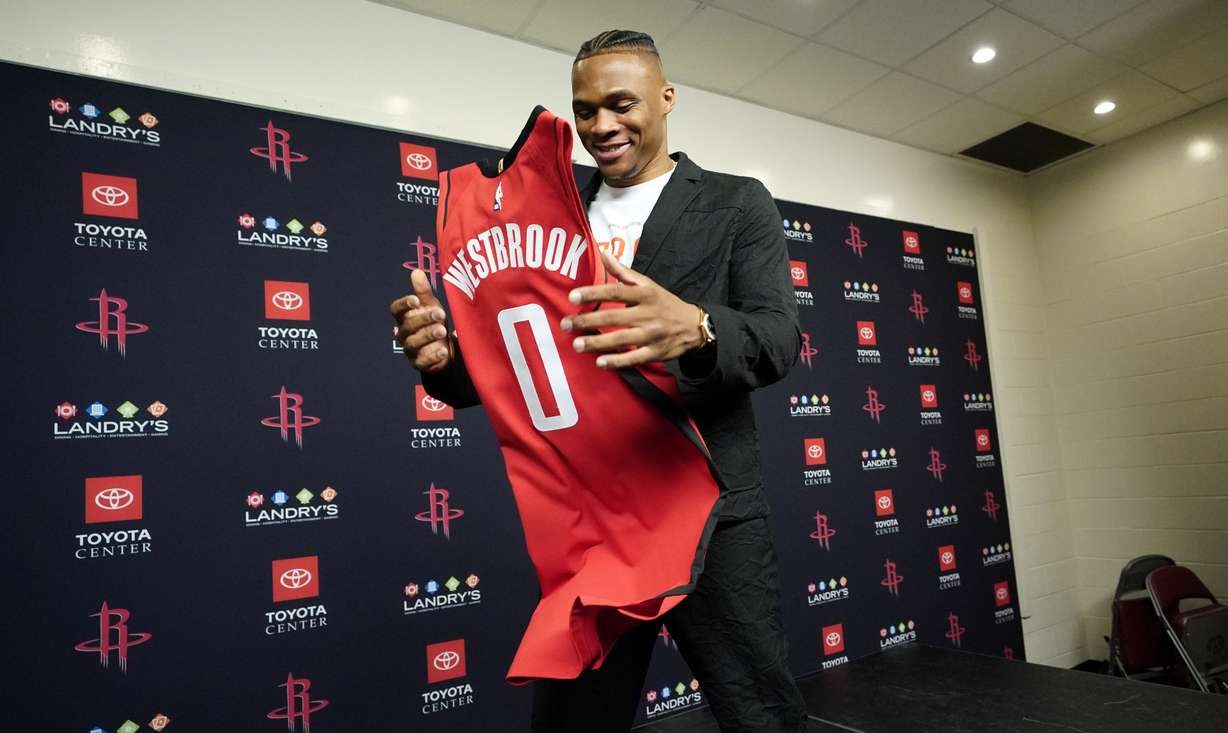 Recently acquired Houston Rockets' guard Russell Westbrook grabs his jersey after an NBA basketball news conference, Friday, July 26, 2019, in Houston. Westbrook was acquired from the Oklahoma City Thunder. (AP Photo/David J. Phillip)