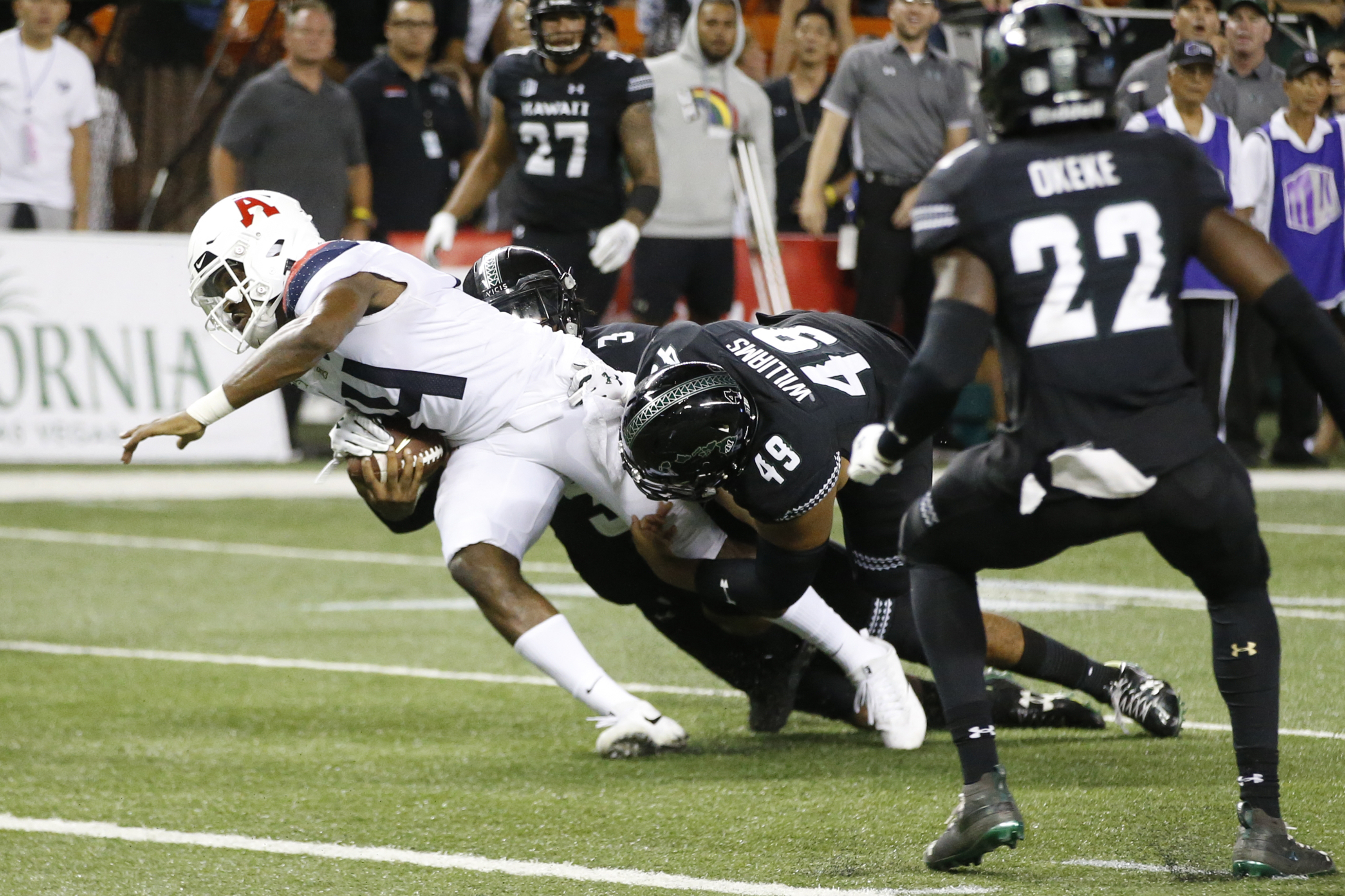 With no time left in the 4th quarter, Hawaii defensive back Kalen Hicks (3) and defensive lineman Manly Williams (49) tackle Arizona quarterback Khalil Tate (14) just short of the end zone during an NCAA college football game, Saturday, Aug. 24, 2019, in Honolulu, Hawaii. (Photo: Marco Garcia, AP Photo)
