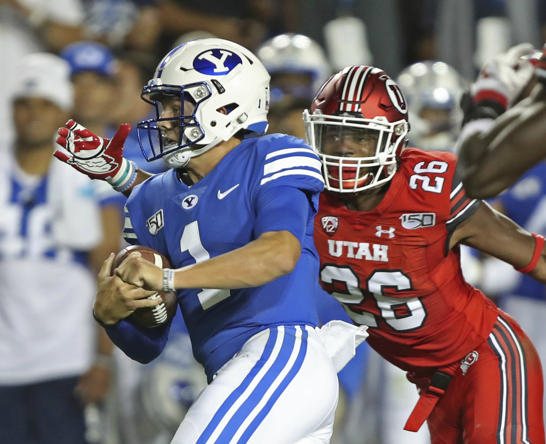 BYU quarterback Zach Wilson (1) runs past Utah defensive back Terrell Burgess (26) for a first down during the first half of an NCAA college football game Thursday, Aug. 29, 2019, in Provo, Utah. (Photo: George Frey, AP)