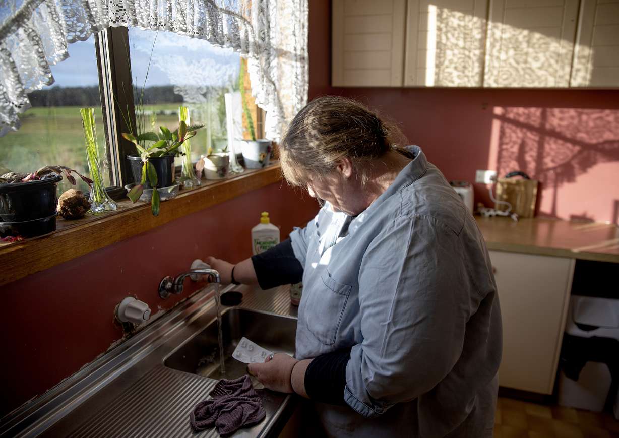 Carmall Casey washes pills from an old pack of tapentadol down the sink while going through her box of medicine in her kitchen in Black River, Tasmania, Australia, Wednesday, July 24, 2019. Photo: David Goldman, AP Photo