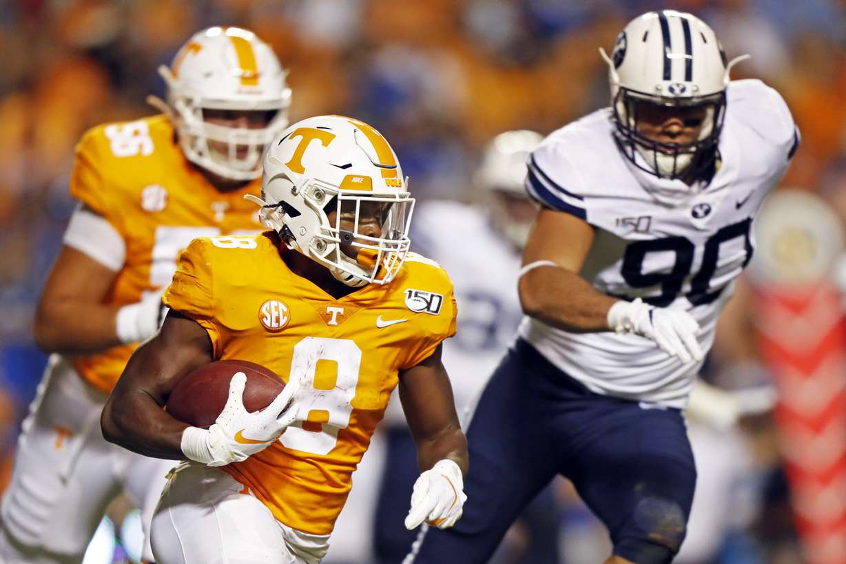 Tennessee running back Ty Chandler (8) outruns Brigham Young defensive lineman Devin Kaufusi (90) in the first half of an NCAA college football game Saturday, Sept. 7, 2019, in Knoxville, Tenn. (AP Photo/Wade Payne)