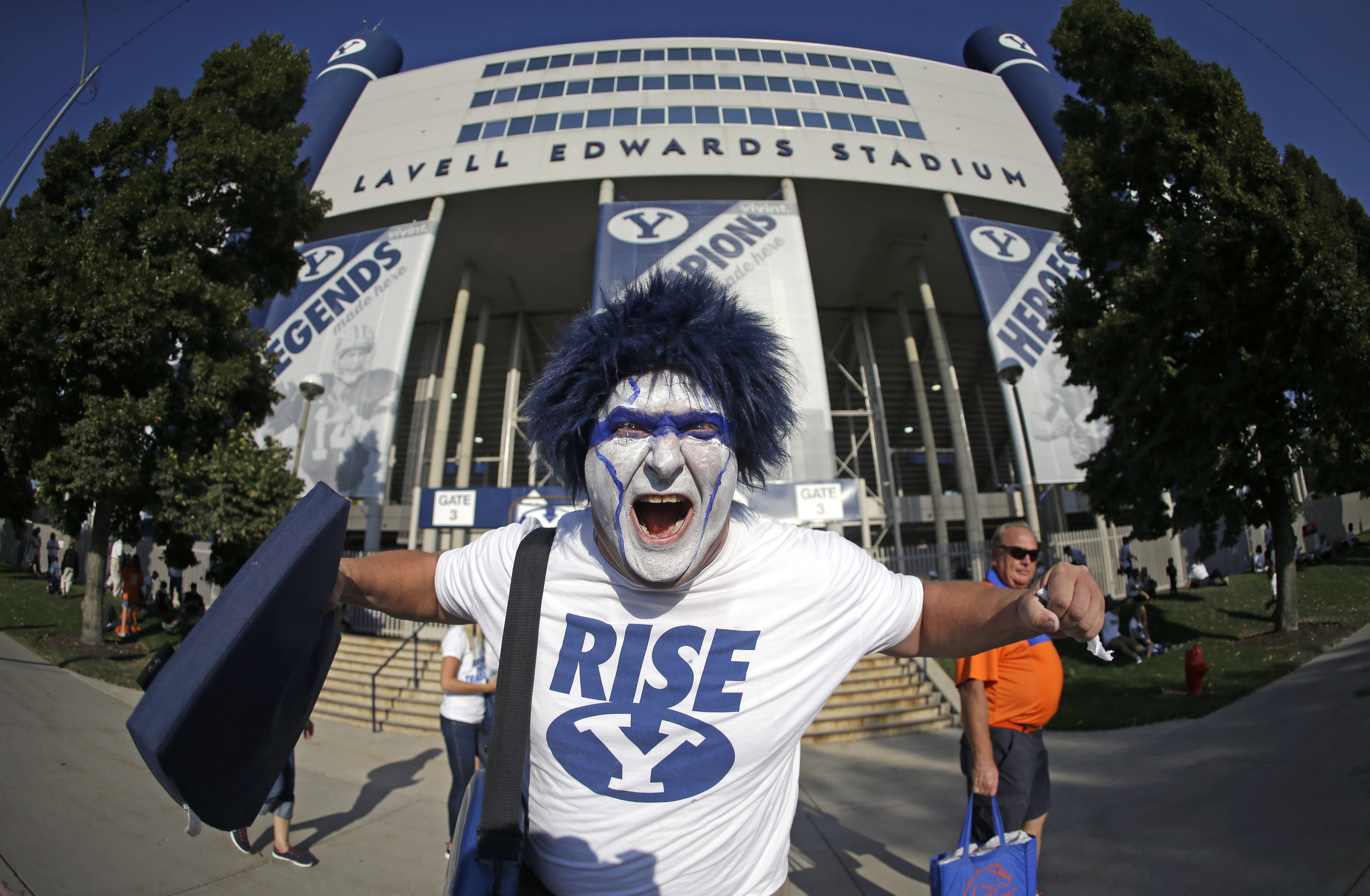 FILE - BYU fan Kerry Olsen poses for a photo in front of LaVell Edwards Stadium before the start of their NCAA college football game against Boise State, Saturday, Sept. 12, 2015, in Provo, Utah. (AP Photo/Rick Bowmer)