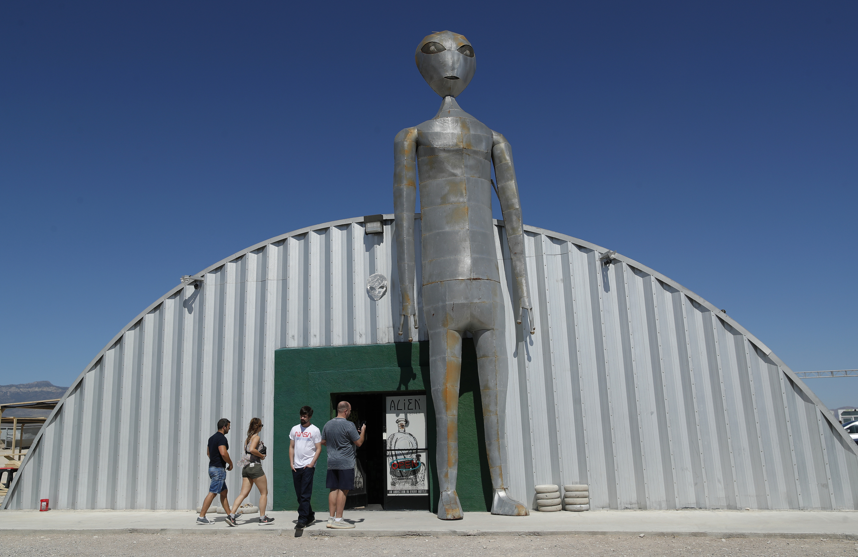 People enter and exit the Alien Research Center in Hiko, Nev. No one knows what to expect, but lots of people are preparing for "Storm Area 51" on Wednesday, Sept. 18, 2019, in the Nevada desert. Neighbors, elected officials and experts say the craze sparked by an internet joke inviting people to ""see them aliens" might become a cultural marker, a dud or something in-between. (AP Photo/John Locher)