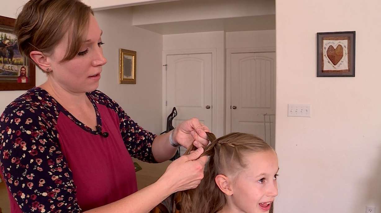 Laura Munn braids her daughter's hair. (Photo: KSL TV)