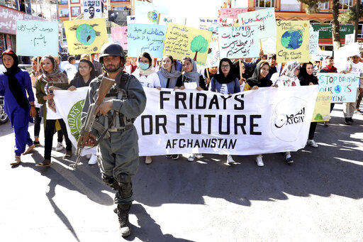 Young people attend a Climate Strike rally, as Afghan security forces guard them in Kabul, Afghanistan, Friday, Sept. 20, 2019. In the Afghan capital, where people are dying every day in horrific bomb attacks, a young generation, worried that if war doesn't kill them climate change will, took part in the global climate strike. (AP Photo/Ebrahim Noroozi)