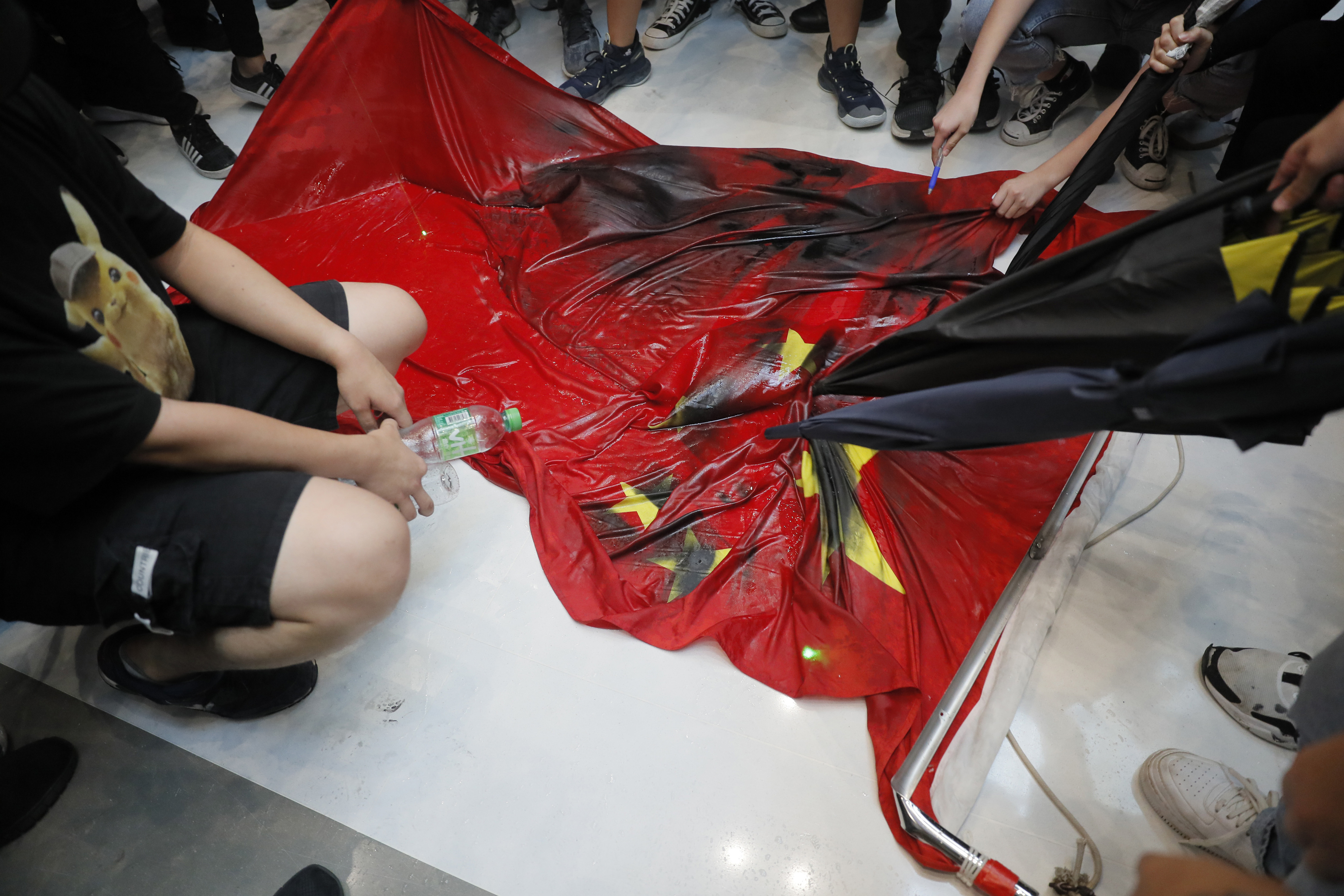 The Latest: Hong Kong protesters trample Chinese flag
