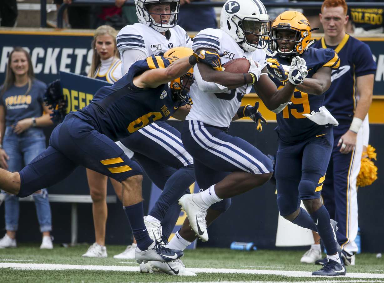 Brigham Young Cougars running back Emmanuel Esukpa (33) breaks tackles from Toledo Rockets defensive back Samuel Womack (19) and Mitchell Guadagni (6) on his way to a touchdown during the first half of an NCAA football game at The Glass Bowl in Toledo, Ohio on Saturday, Sept. 28, 2019. (Photo: Colter Peterson, KSL)
