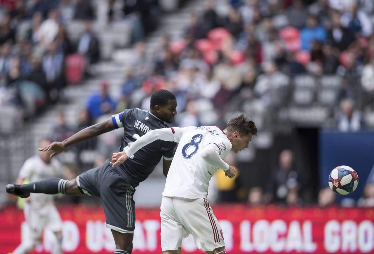 Real Salt Lake's Damir Kreilach (8) gets his head on the ball and scores a goal as Vancouver Whitecaps' Doneil Henry (2) defends during the first half of an MLS soccer match in Vancouver, British Columbia, Sunday, Oct. 6, 2019. (Photo: Darryl Dyck, The Canadian Press via AP)