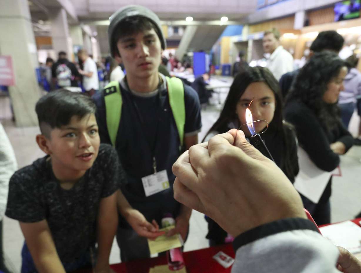 Students watch as Michelle Tuitupou, academic adviser for the geology department at the University of Utah, uses a flame to straighten a piece of shape memory alloy during the Multicultural Youth Leadership Summit at Salt Lake Community College in Taylorsville on Monday, Oct. 7, 2019. (Photo: Steve Griffin, KSL)