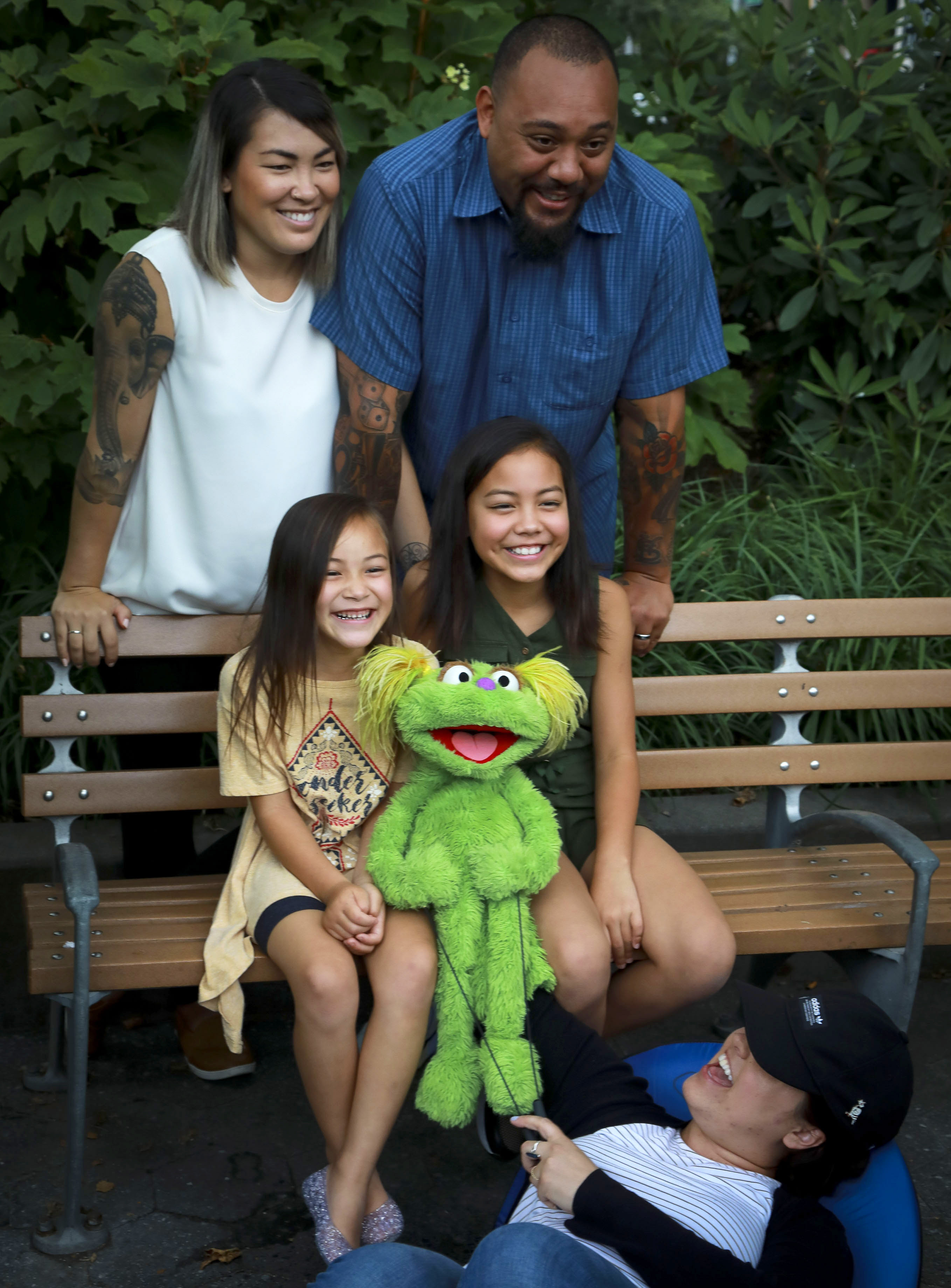 This Aug. 6, 2019 photo shows Jaana, standing left, and Sam Woodbury, from Irvine, Cali., and their daughters Salia, 10, seated right, and Kya, 6, with "Sesame Street" muppet Karli and puppeteer Haley Jenkins in New York. Salia, whose parents are in recovery, is featured with Karli in a segment about addiction. The initiative is part of the Sesame Street in Communities resources available online. (Photo: Bebeto Matthews, AP Photo.)