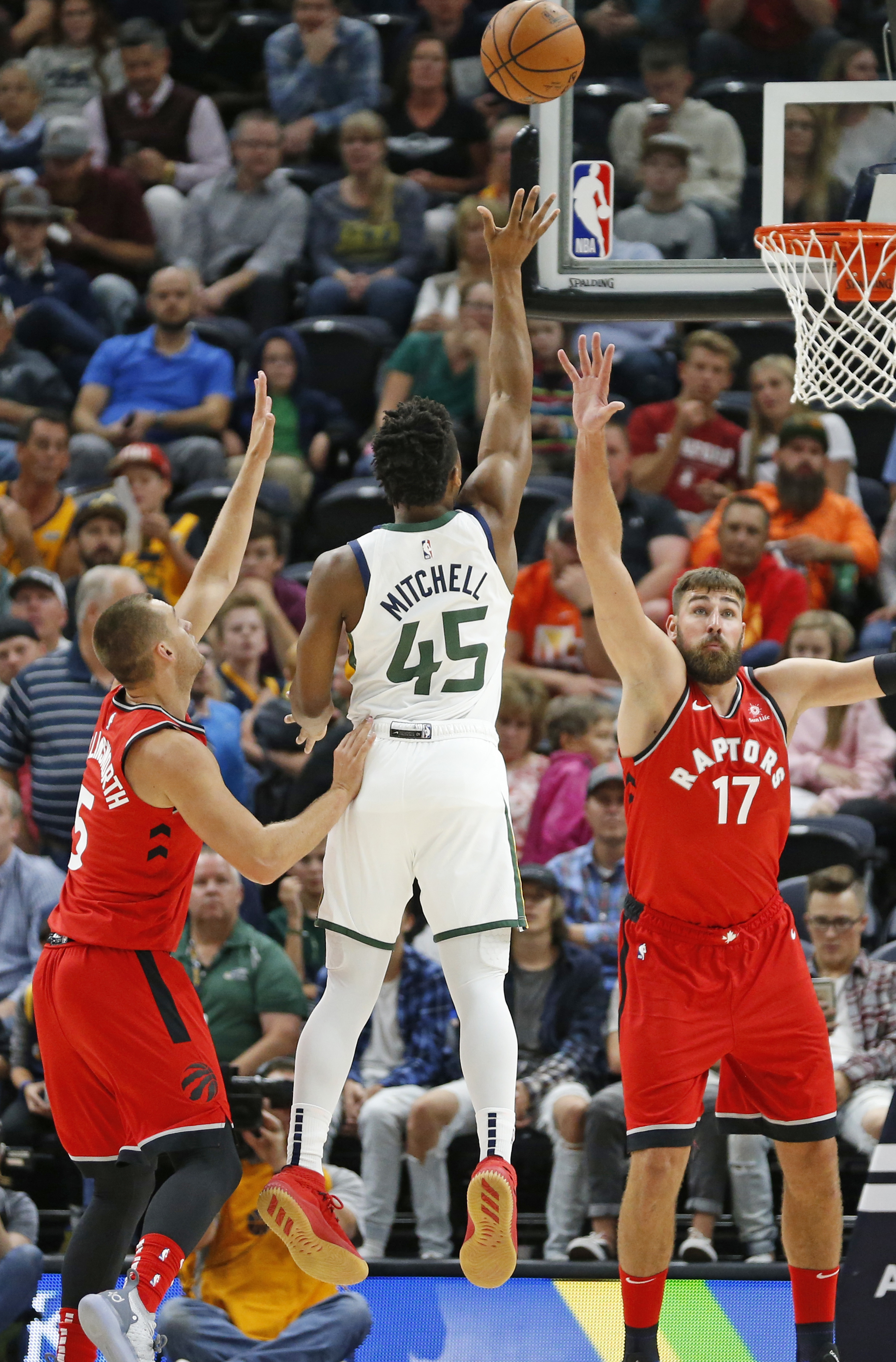 Utah Jazz guard Donovan Mitchell (45) shoots as Toronto Raptors' Kyle Collinsworth (5) and Jonas Valanciunas (17) defend in the first half during an NBA preseason basketball game Tuesday, Oct. 2, 2018, in Salt Lake City. (Photo: Rick Bowmer, AP)