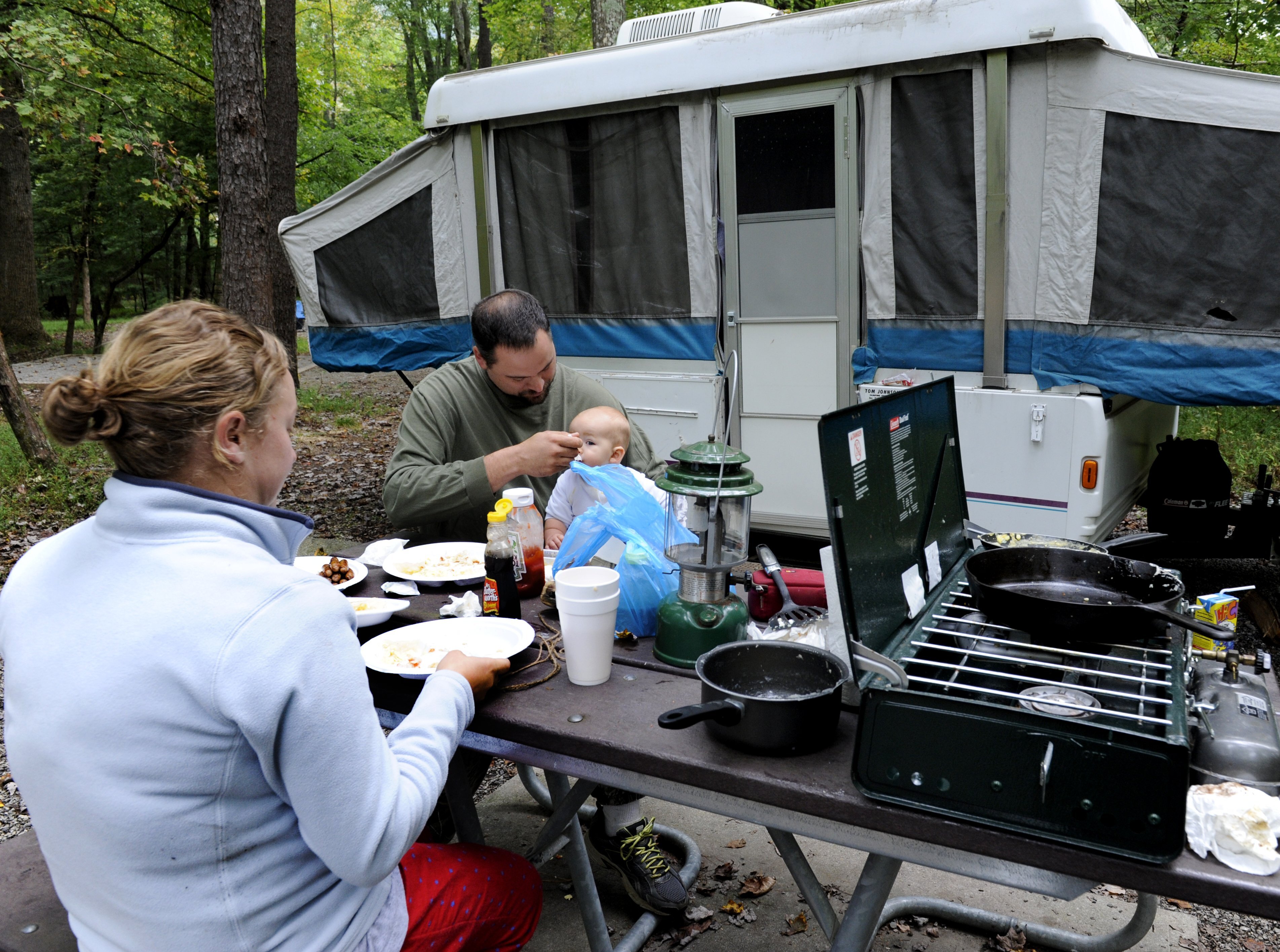 FILE - In this Oct. 1, 2013, file photo, Brandon and Cassie Hyde of Andrews, N.C, with 8-month-old Brooklyn, camp at Cades Cove in the Great Smoky Mountain National Park near Townsend, Tenn. The Interior Department is considering recommendations to modernize campgrounds within the National Park Service. (Michael Patrick/Knoxville News Sentinel via AP, File)