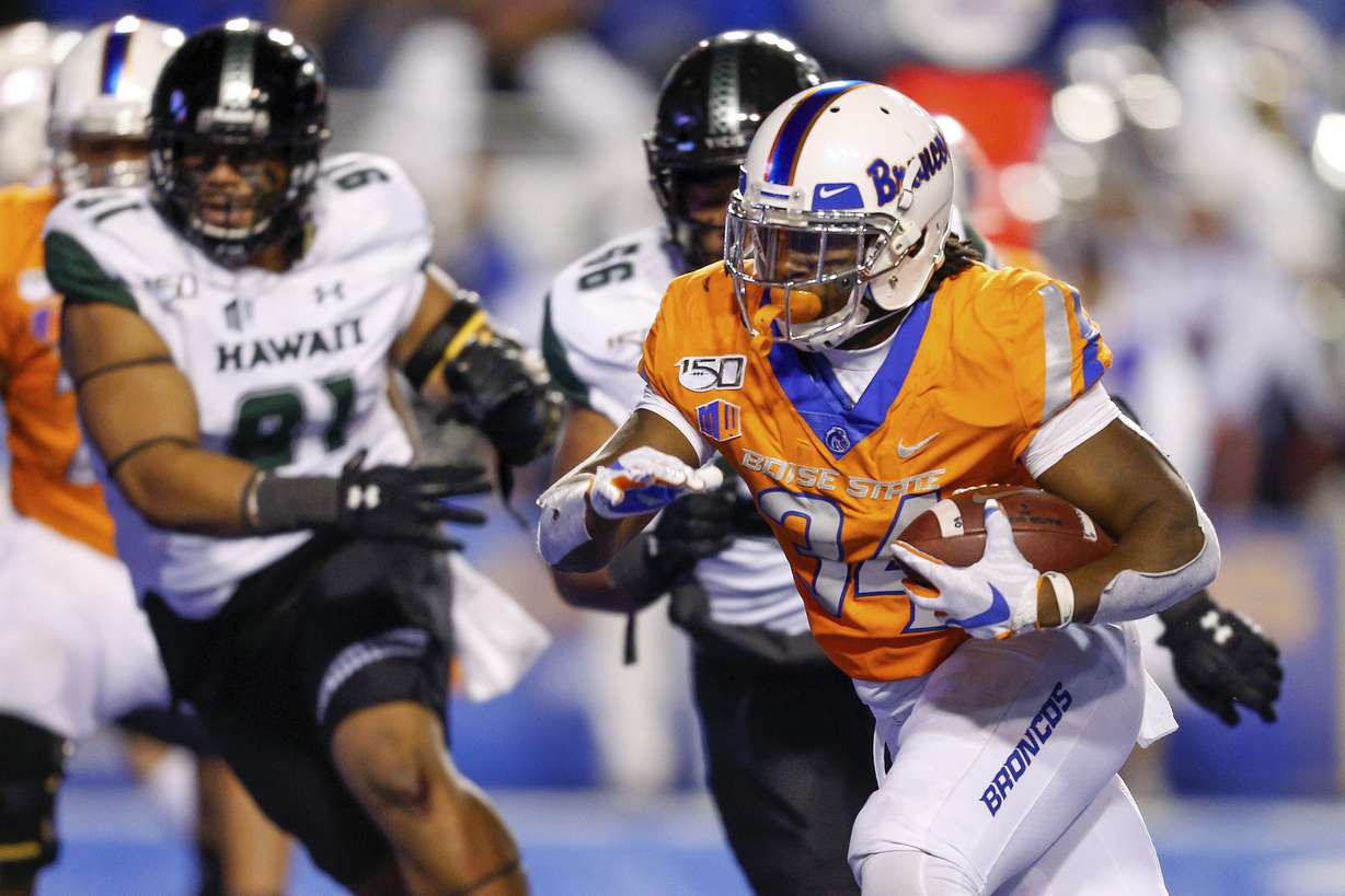 Boise State running back Robert Mahone, right runs past the Hawaii defense for a 13-yard touchdown during the first half of an NCAA college football game Saturday, Oct. 12, 2019, in Boise, Idaho. (Photo: Steve Conner, AP)